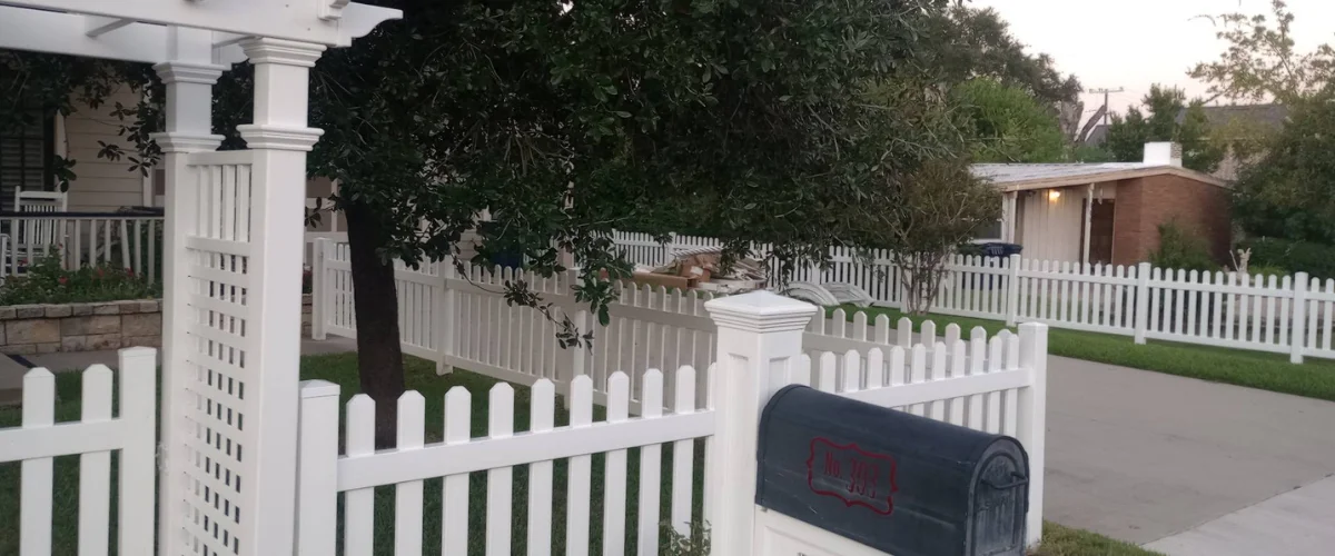White picket fence with mailbox in suburban neighborhood