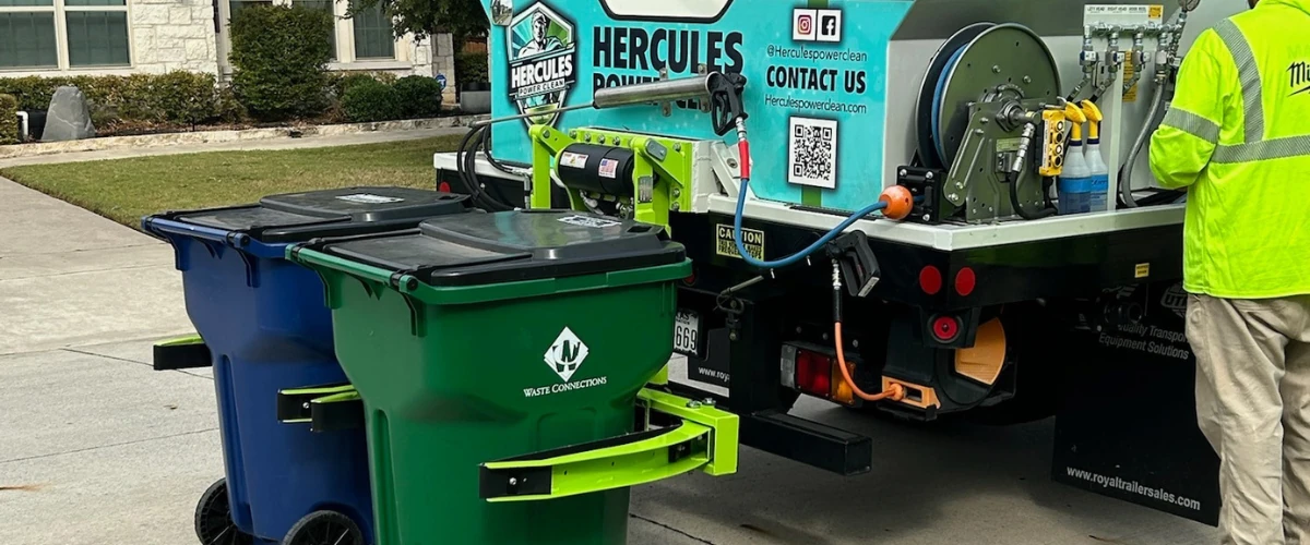 Trash bin cleaning service truck parked curbside beside residential garbage bins