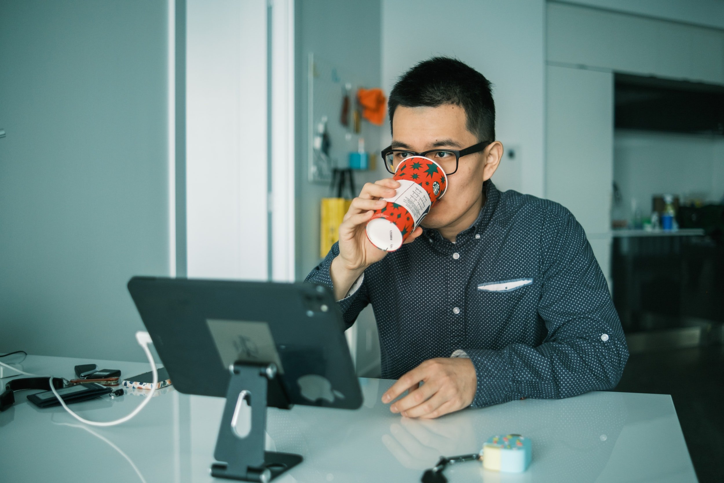 Office guy drinking coffee while working on the computer