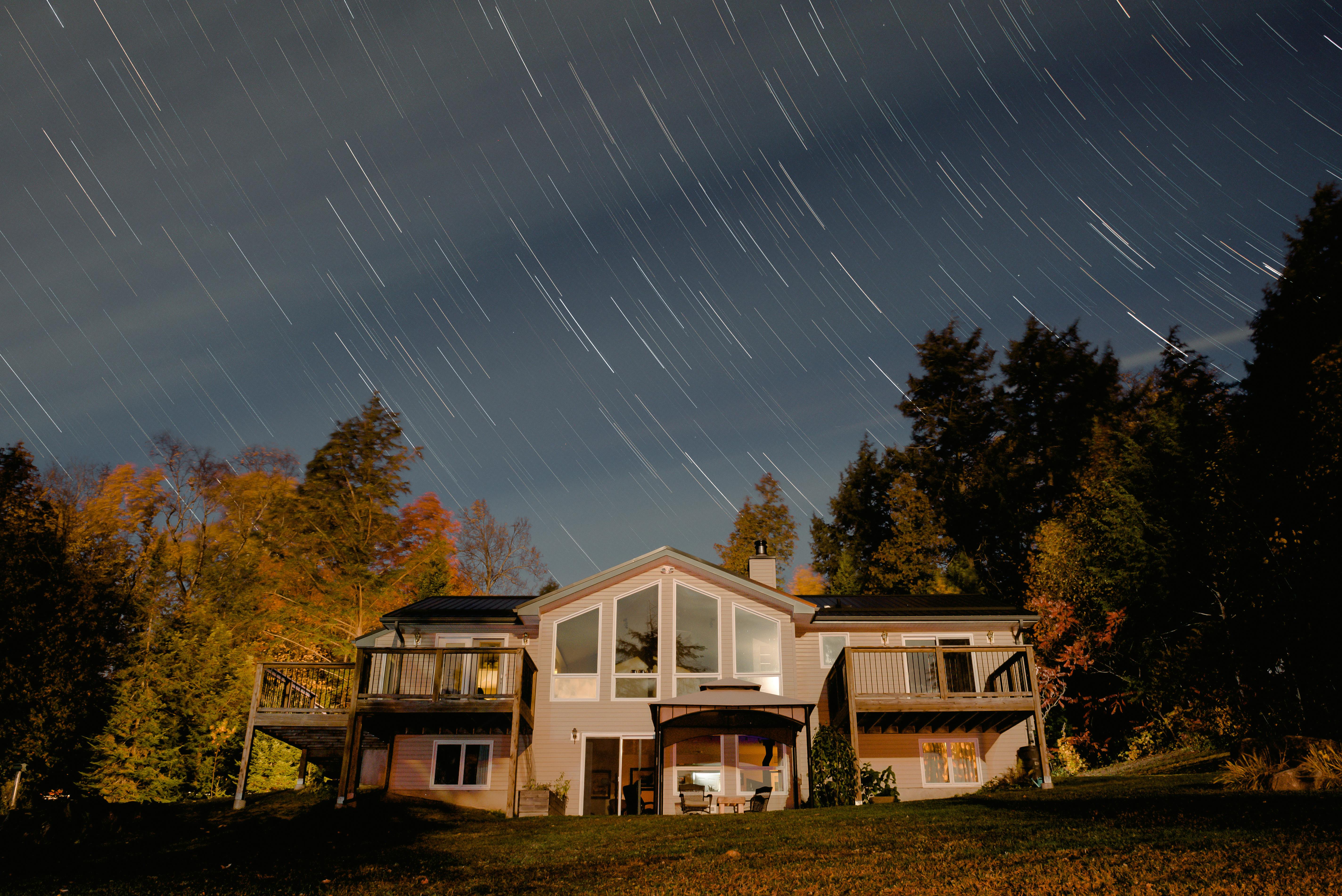 Lightbulb glowing above a house model, symbolizing knowledge and ideas in real estate