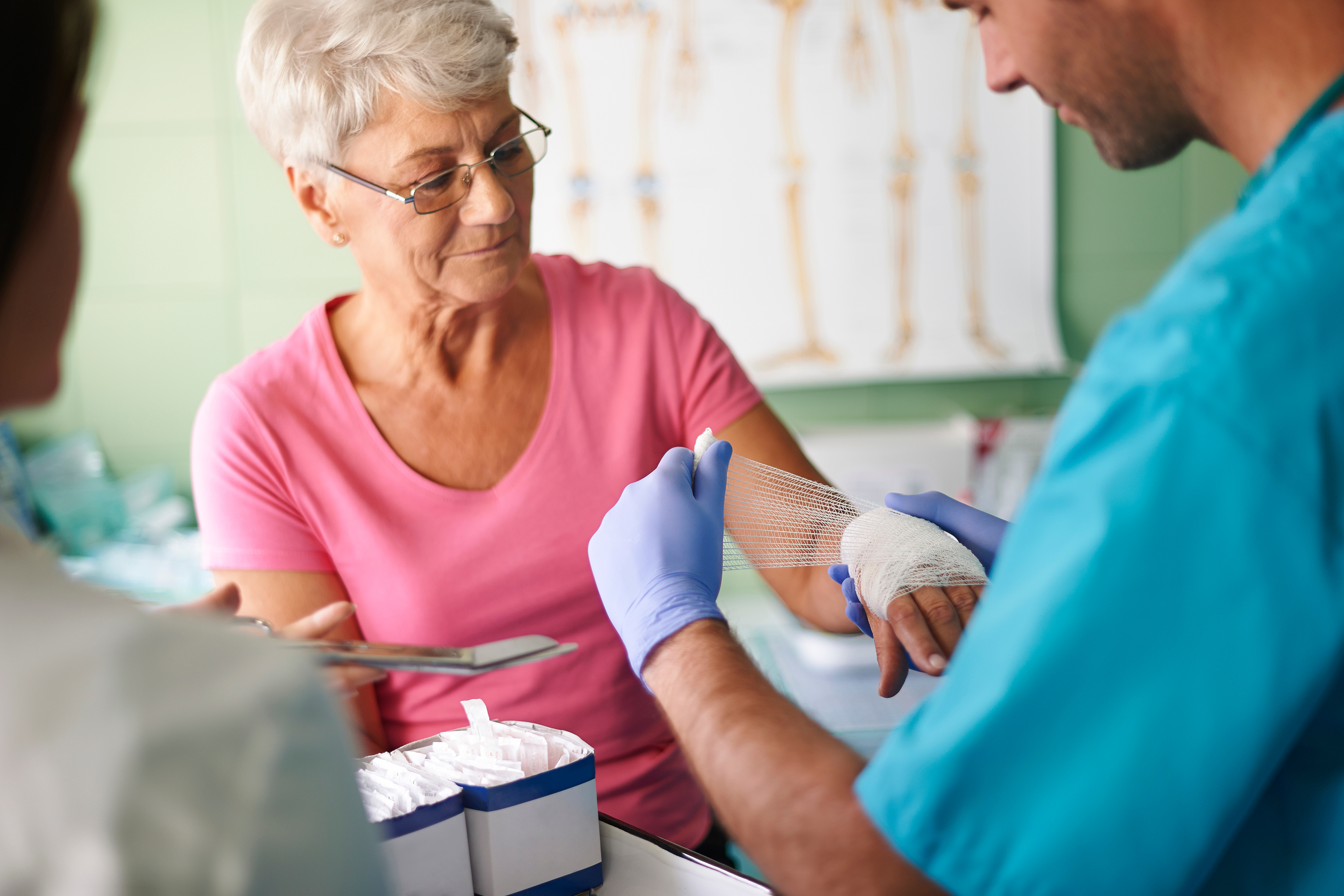 Royal Wound Care specialist bandaging an elderly woman’s hand during a wound care appointment. Royal Wound Care specialist bandaging an elderly woman’s hand during a wound care appointment.