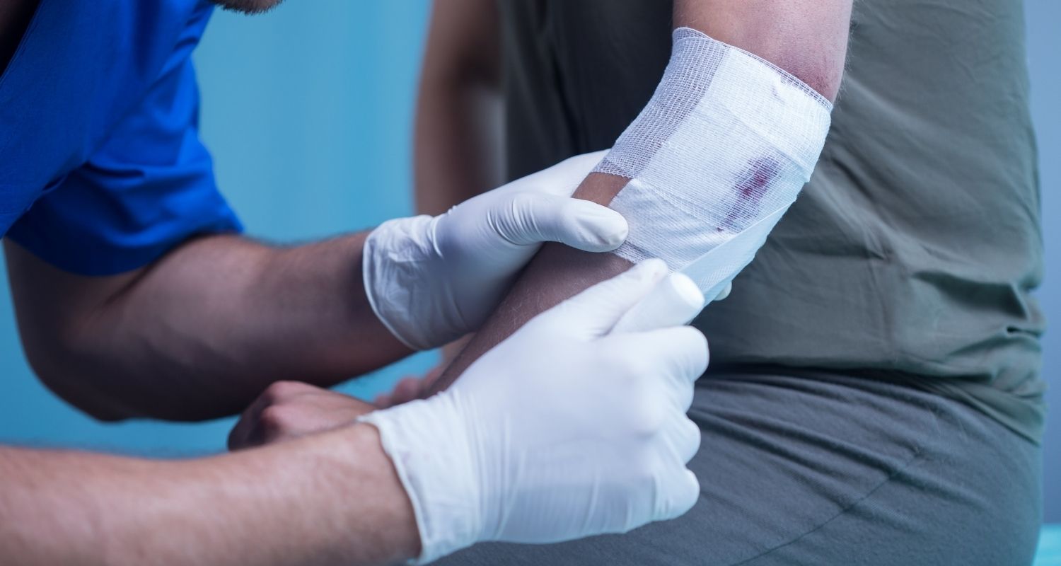 Royal Wound Care specialist providing expert bedside wound care by dressing a patient's arm injury in a skilled nursing facility. Royal Wound Care specialist providing expert bedside wound care by dressing a patient's arm injury in a skilled nursing facility.