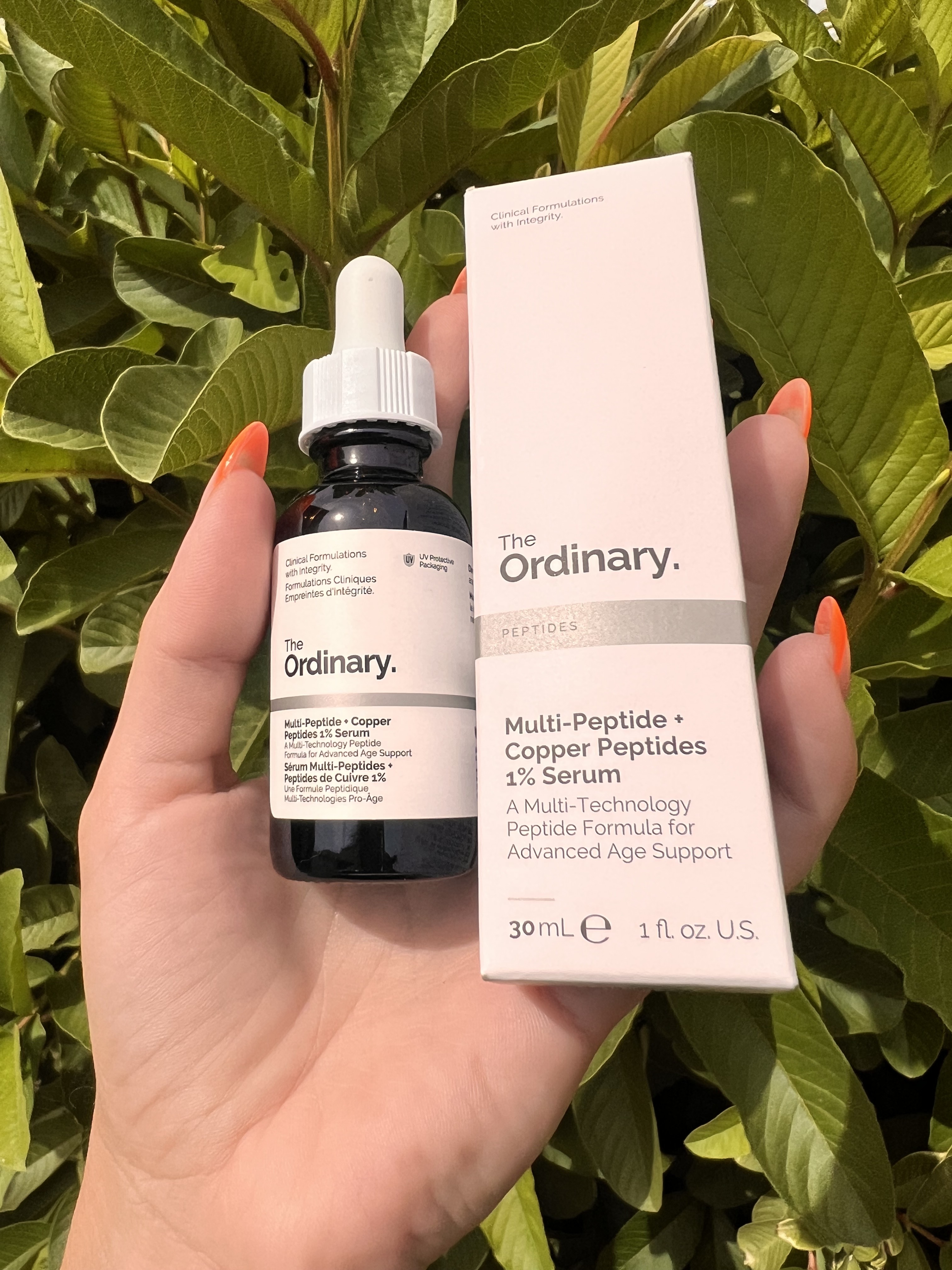 Womans hand holding 'The Ordinary' Multi-Peptide + Copper 1% serum bottle.