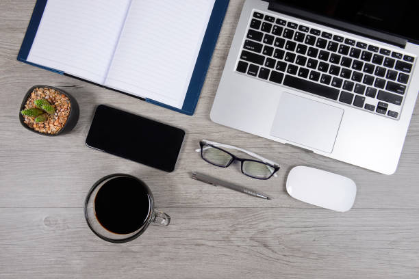 Home office setup with a desk, chair, laptop, notepad, and coffee mug