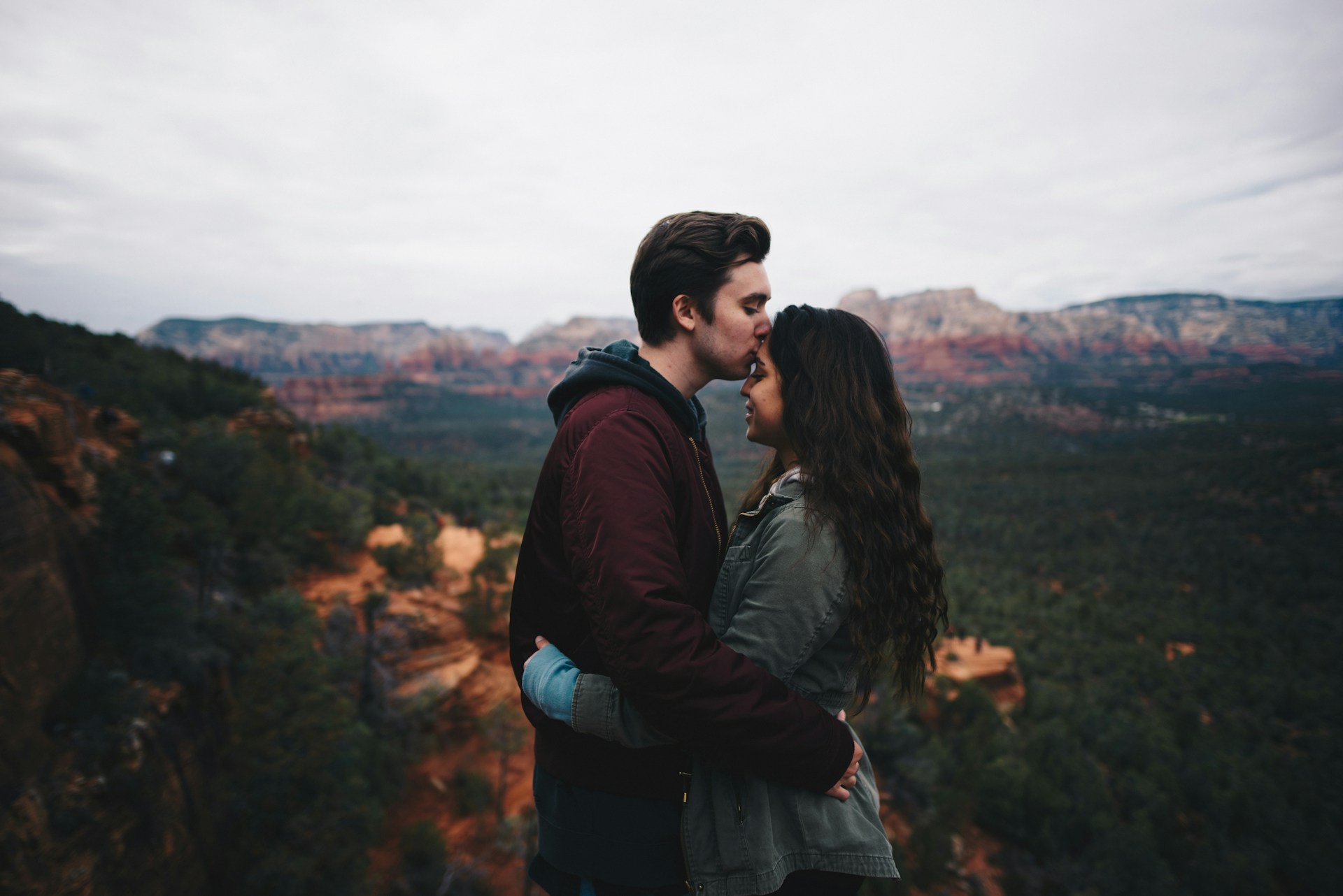 A couple hugging passionately on top of a mountain A couple hugging passionately on top of a mountain