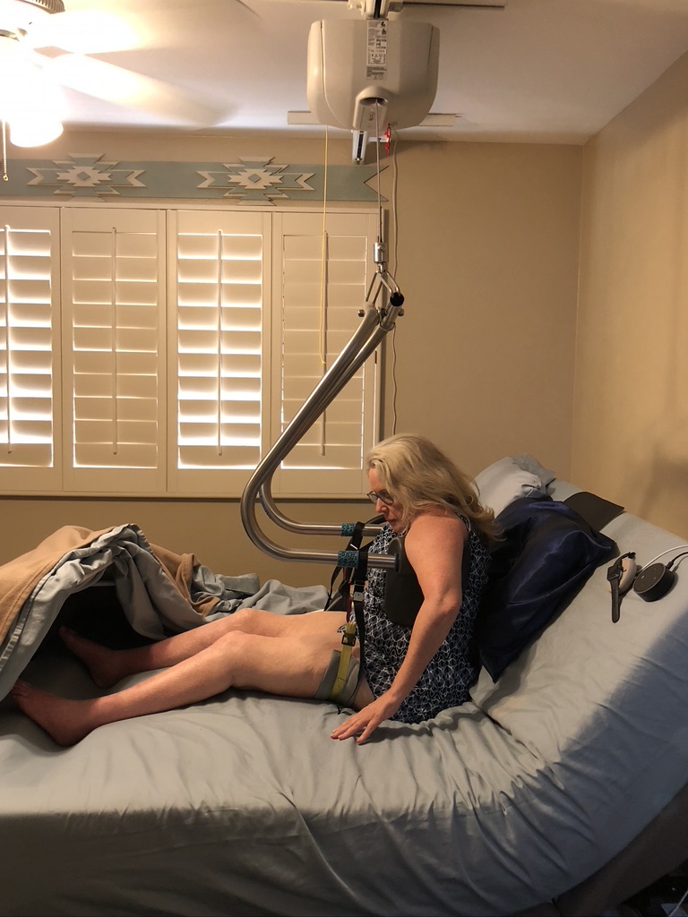 Heather one her adjustable bed being picked up by a ceiling track lift