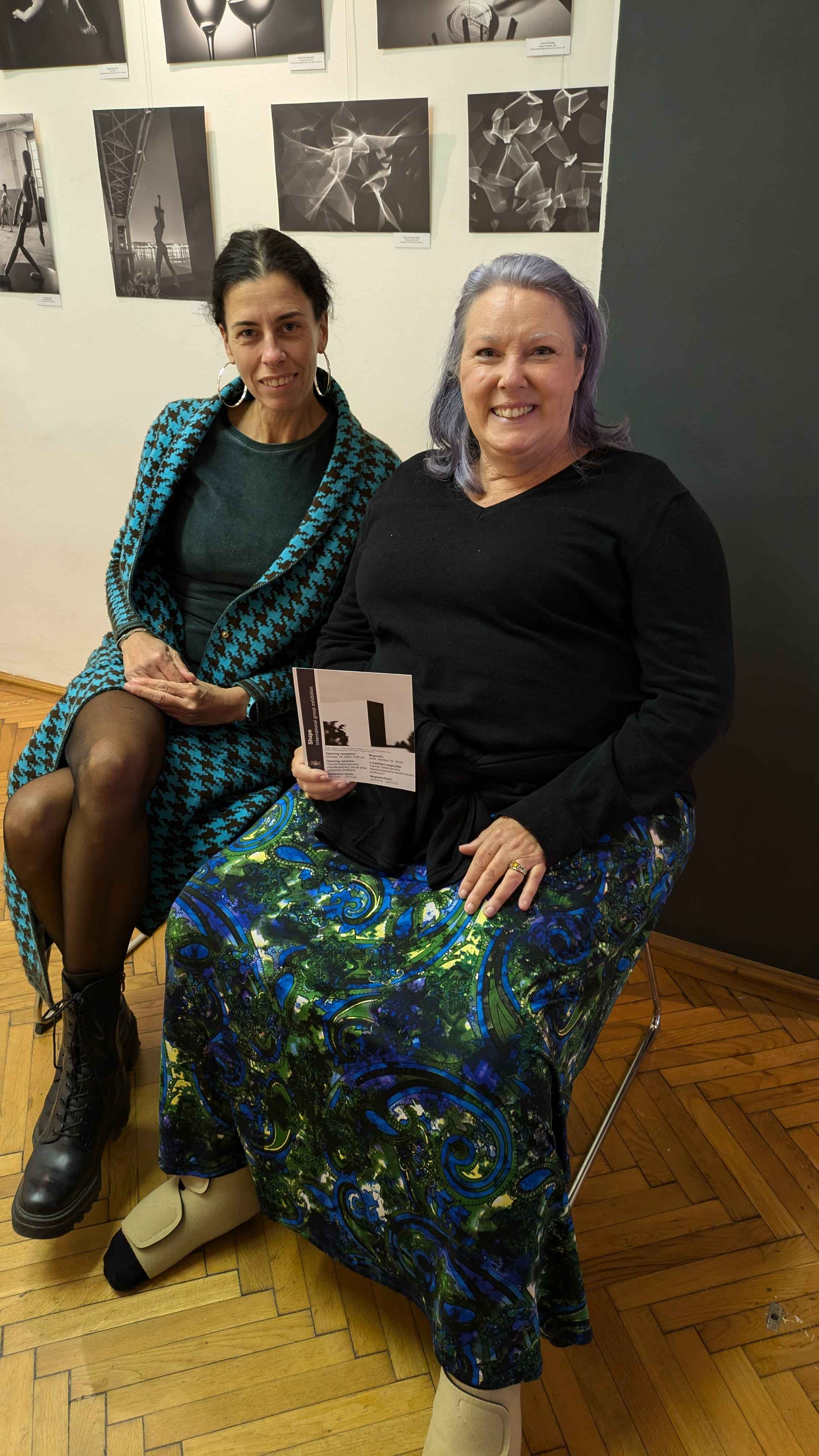 Anita and Heather sitting inside the PH21 gallery on chairs