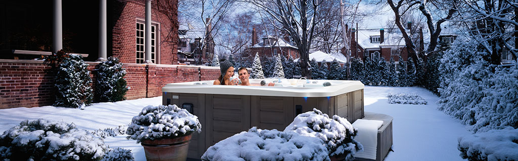 A couple enjoying their backyard spa in the winter
