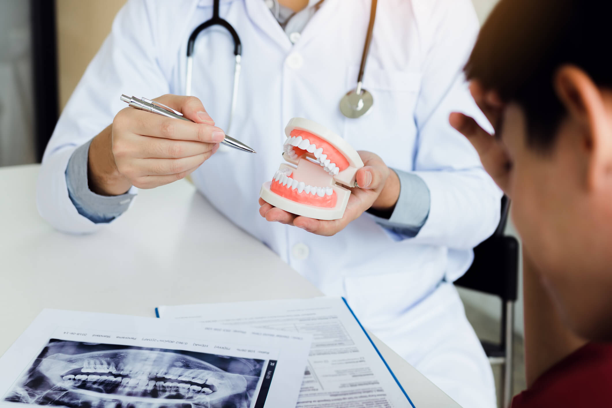 dentist holding a denture during consultation