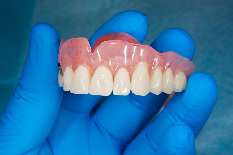 dentist holding a finished upper jaw denture