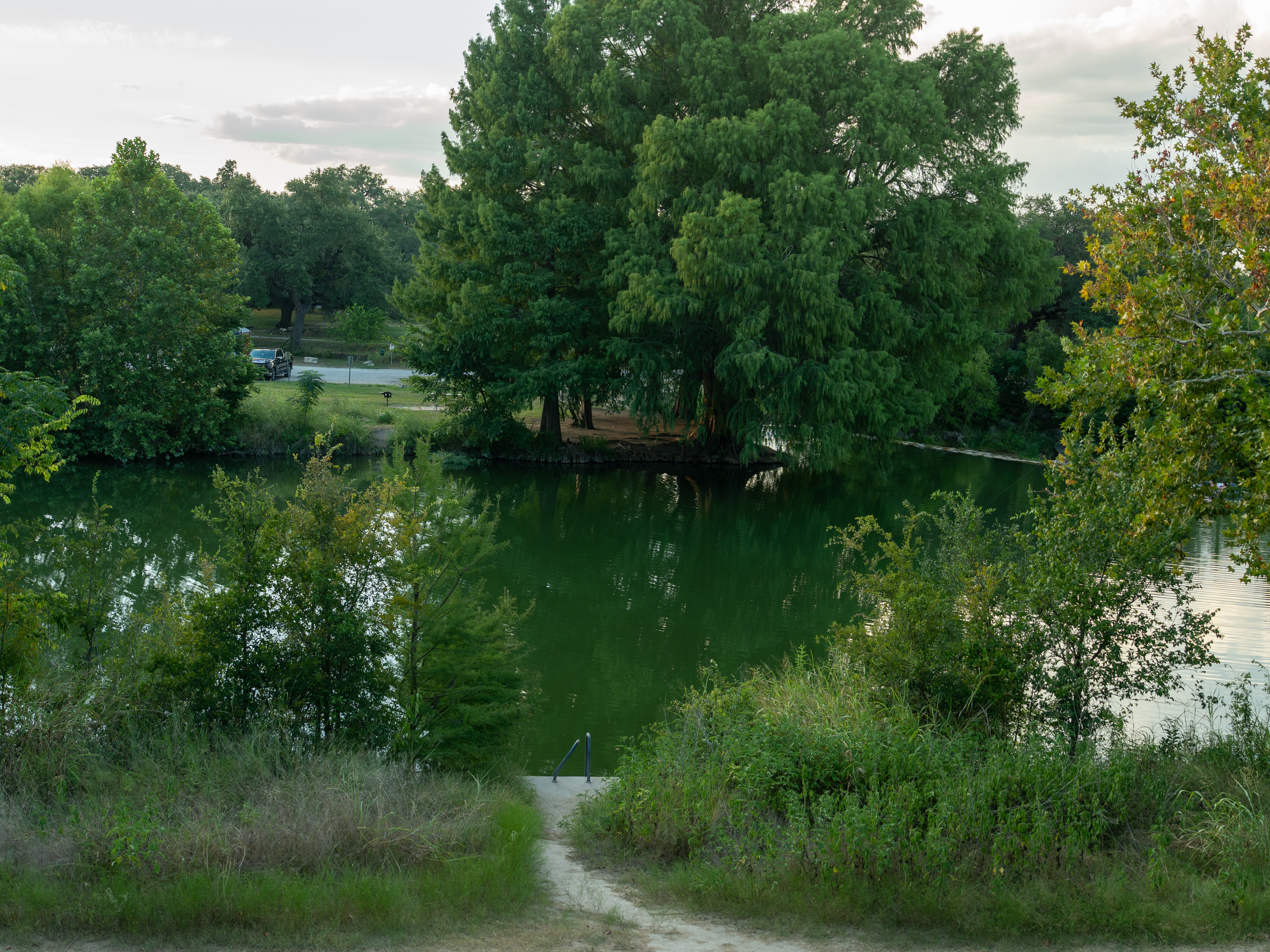 Flowing water over Blanco State Park dam, perfect for fishing, swimming, and Hill Country living