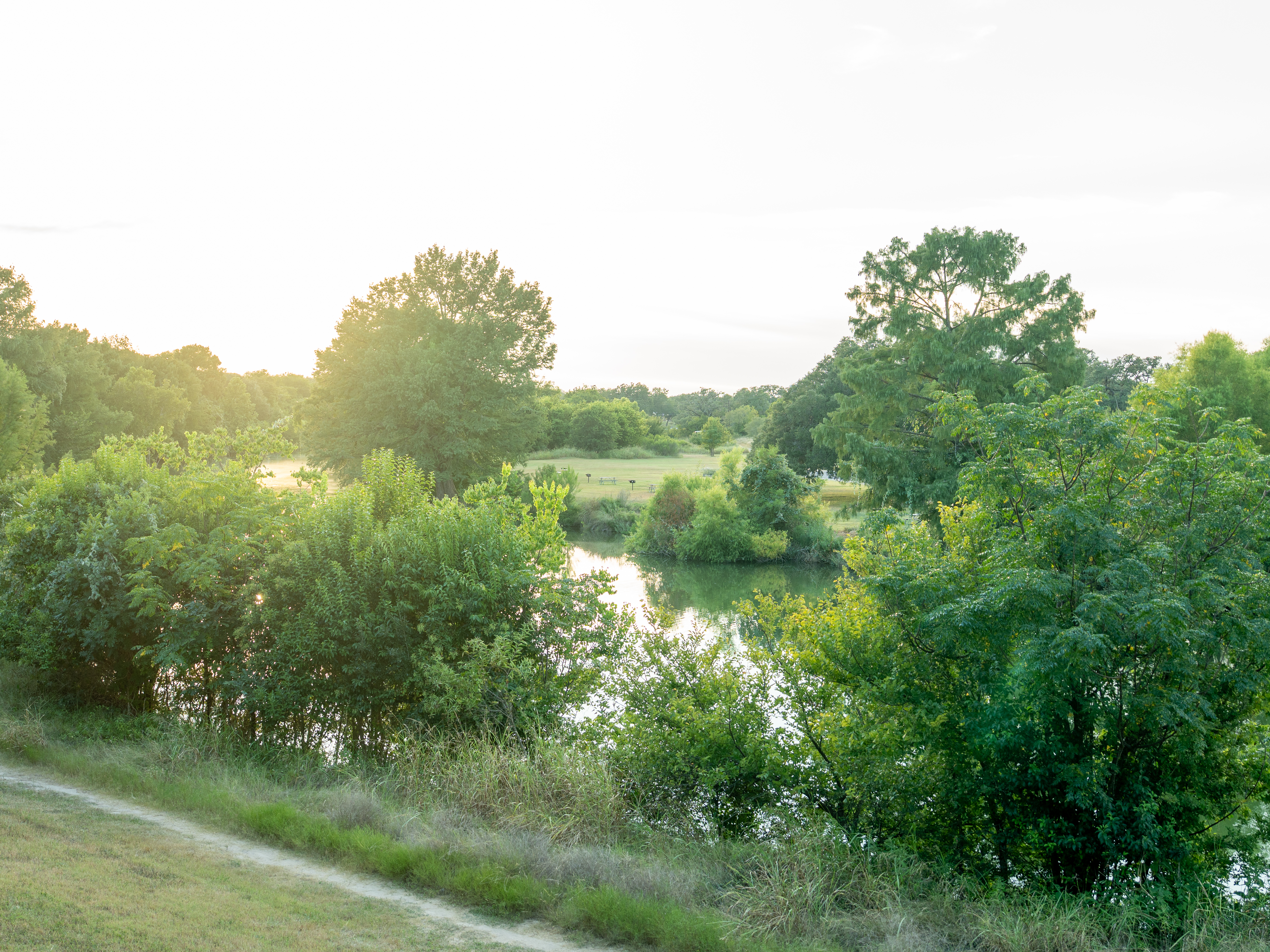 Serene sunset overlooking calm waters at Blanco State Park, a hidden Hill Country retreat
