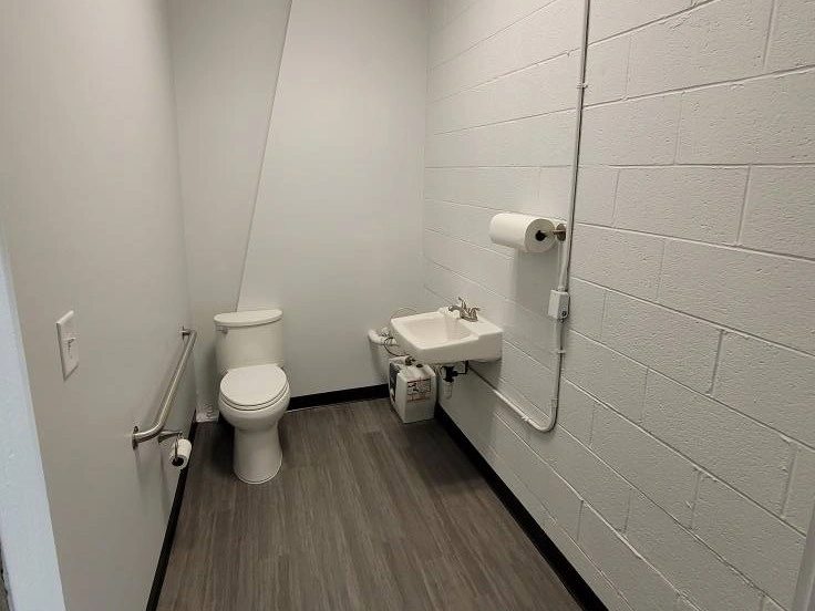 Compact bathroom with a toilet and sink, showcasing a simple design in a limited space.