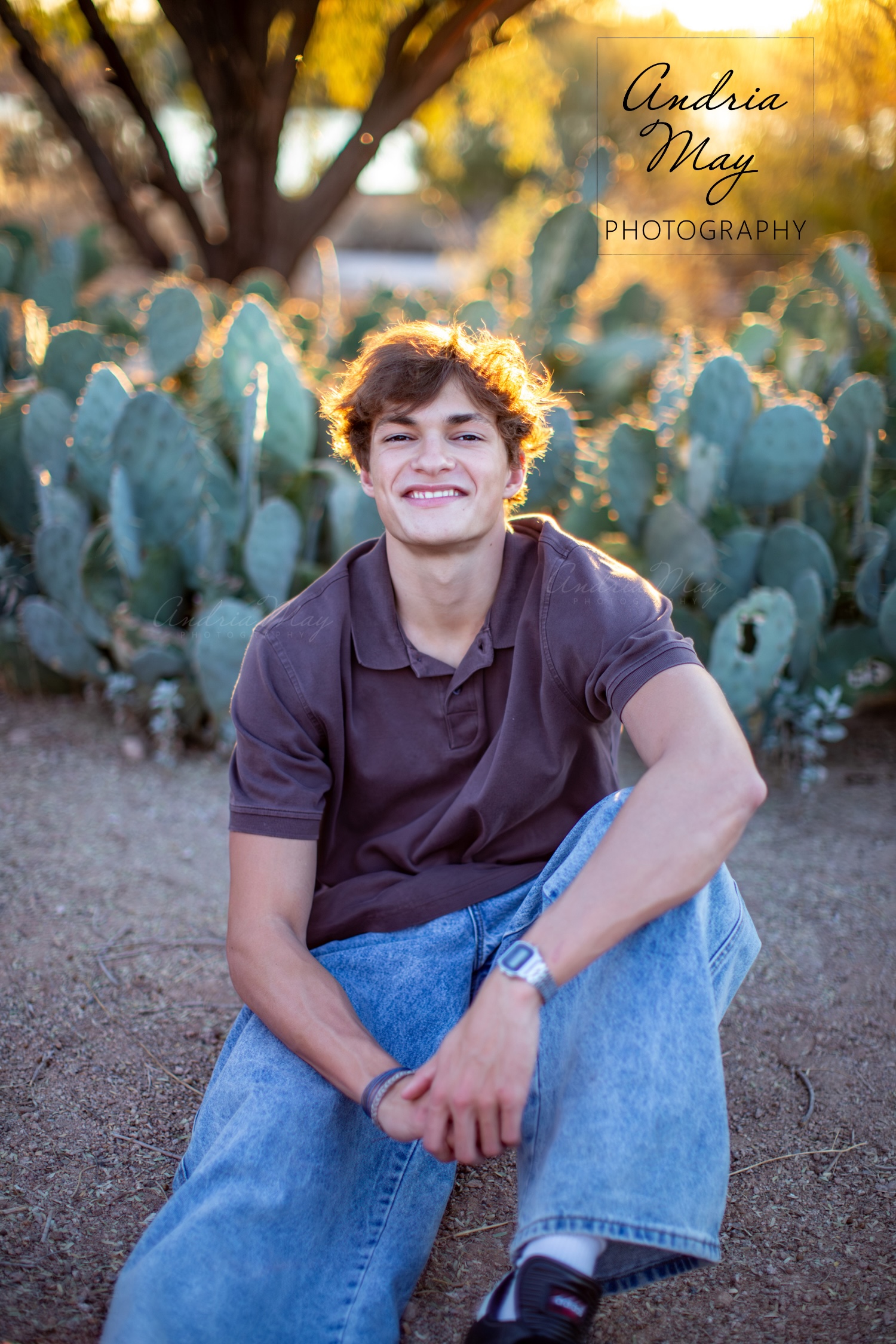 Senior portrait of a high school boy in Chandler, Arizona, standing in front of a cactus with golden sunbeams behind him. A beautifully backlit photo by Andria May Photography. Senior portrait of a high school boy in Chandler, Arizona, standing in front of a cactus with golden sunbeams behind him. A beautifully backlit photo by Andria May Photography.