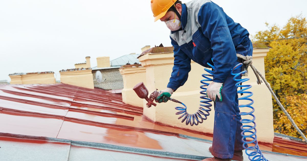 man in blue spraying the roof man in blue spraying the roof