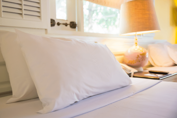 A cozy pillow with a pink satin pillowcase, representing sentimental value and personal comfort in home organization.