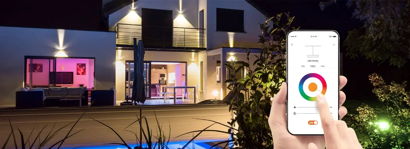 Someone displays a smartphone that controls vibrant, color-changing lights, highlighting the convenience of smart home tech. Someone displays a smartphone that controls vibrant, color-changing lights, highlighting the convenience of smart home tech.
