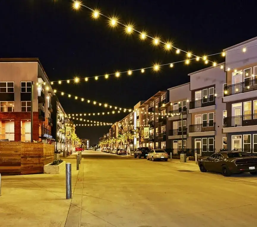 A cozy street scene at night, featuring twinkling lights strung across, enhancing the ambiance of the quiet surroundings. A cozy street scene at night, featuring twinkling lights strung across, enhancing the ambiance of the quiet surroundings.
