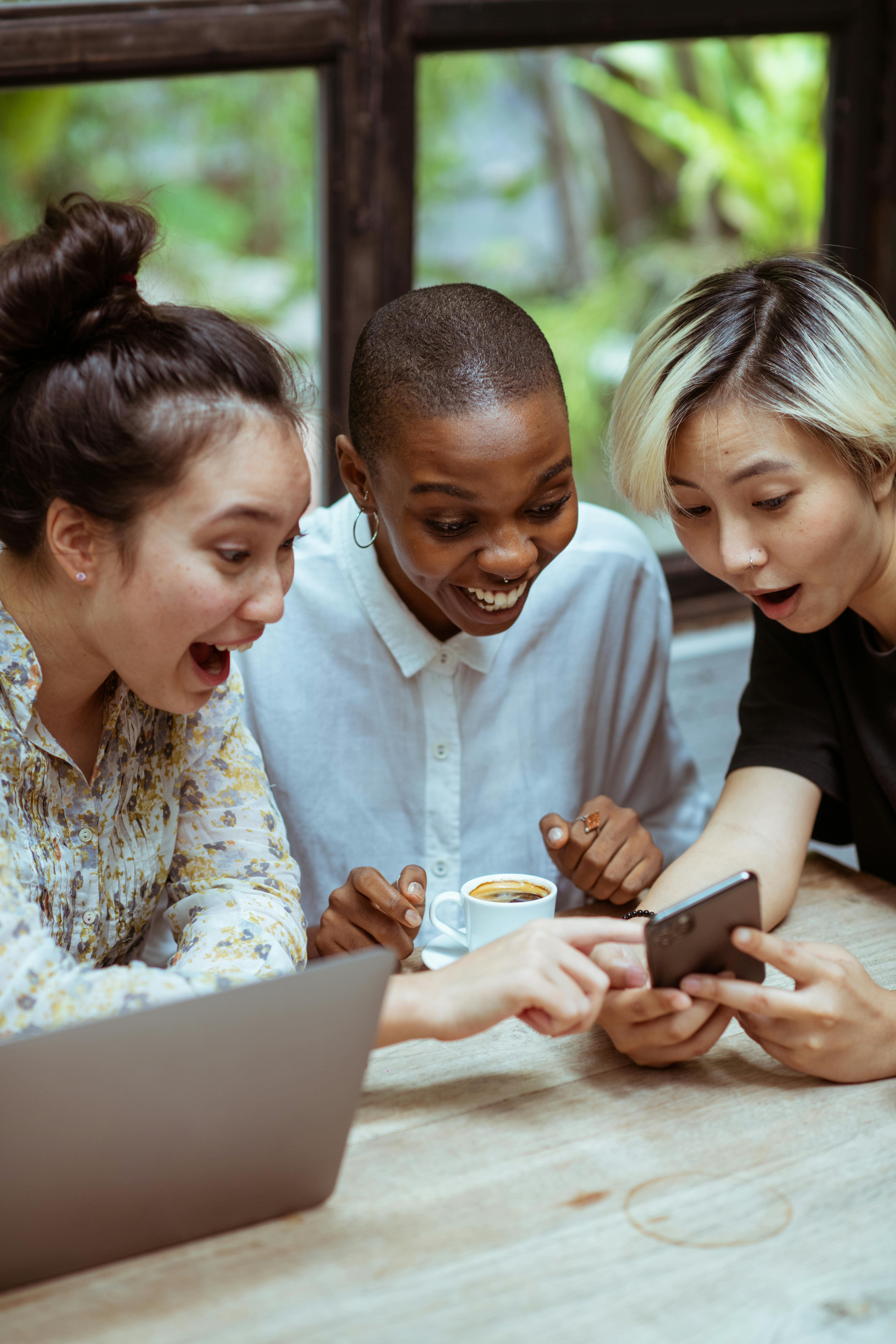 friends laughing and looking at phone friends laughing and looking at phone