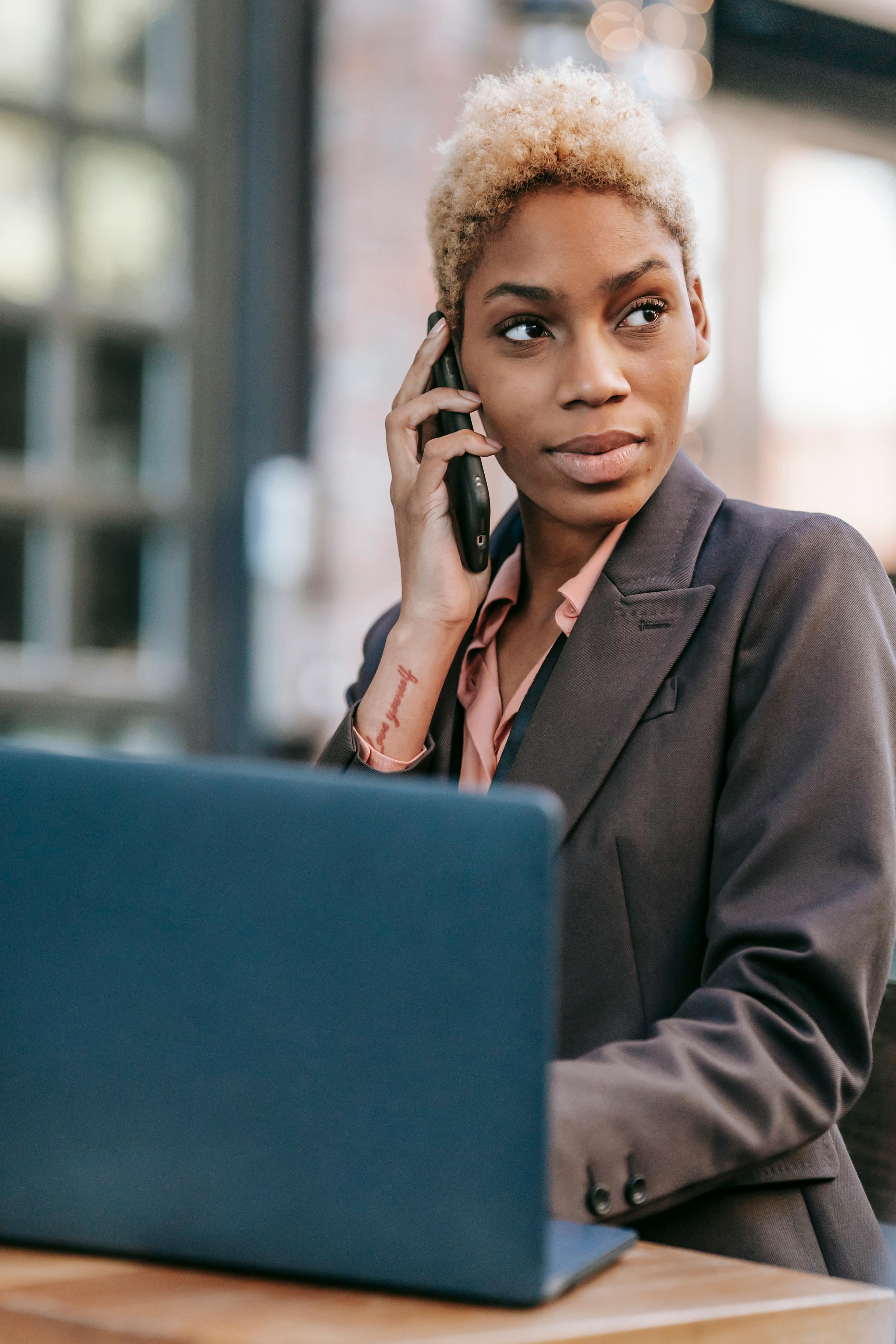 A woman in a business suit engaged in a phone conversation, exuding professionalism and focus. A woman in a business suit engaged in a phone conversation, exuding professionalism and focus.