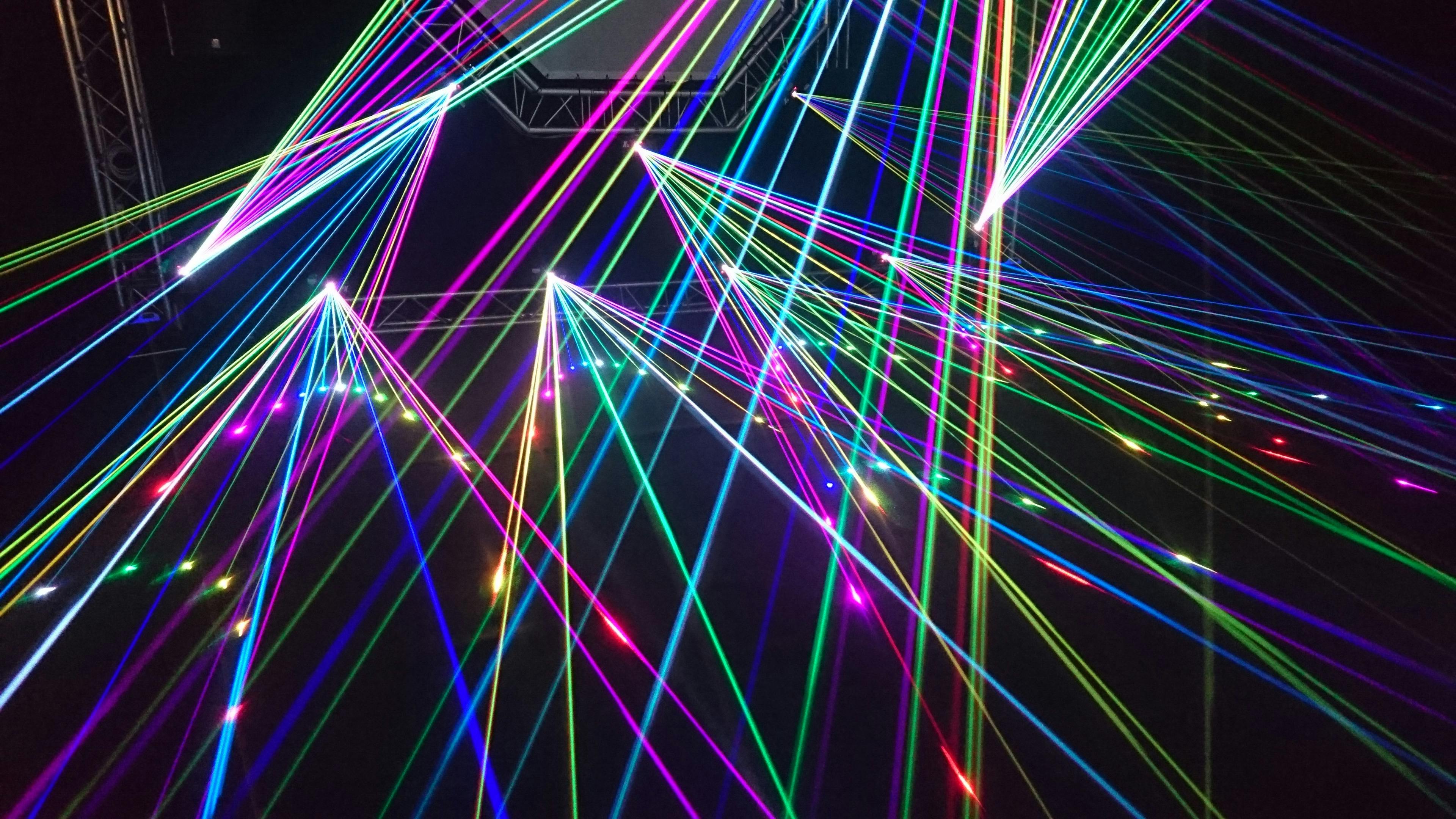 Colorful laser light show illuminating the night sky at an outdoor event, creating a vibrant and dynamic atmosphere. Colorful laser light show illuminating the night sky at an outdoor event, creating a vibrant and dynamic atmosphere.