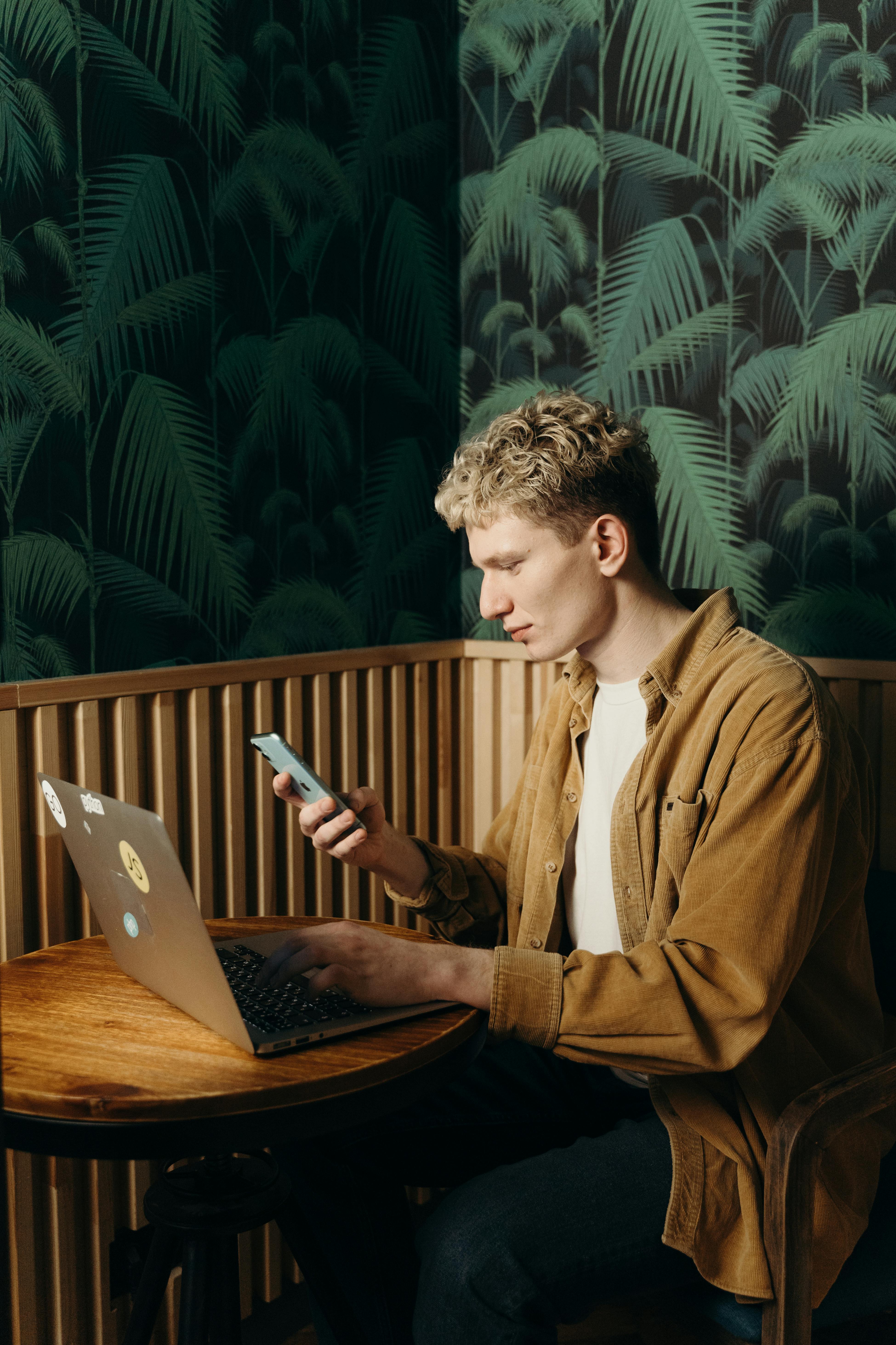 man using mobile phone and laptop man using mobile phone and laptop