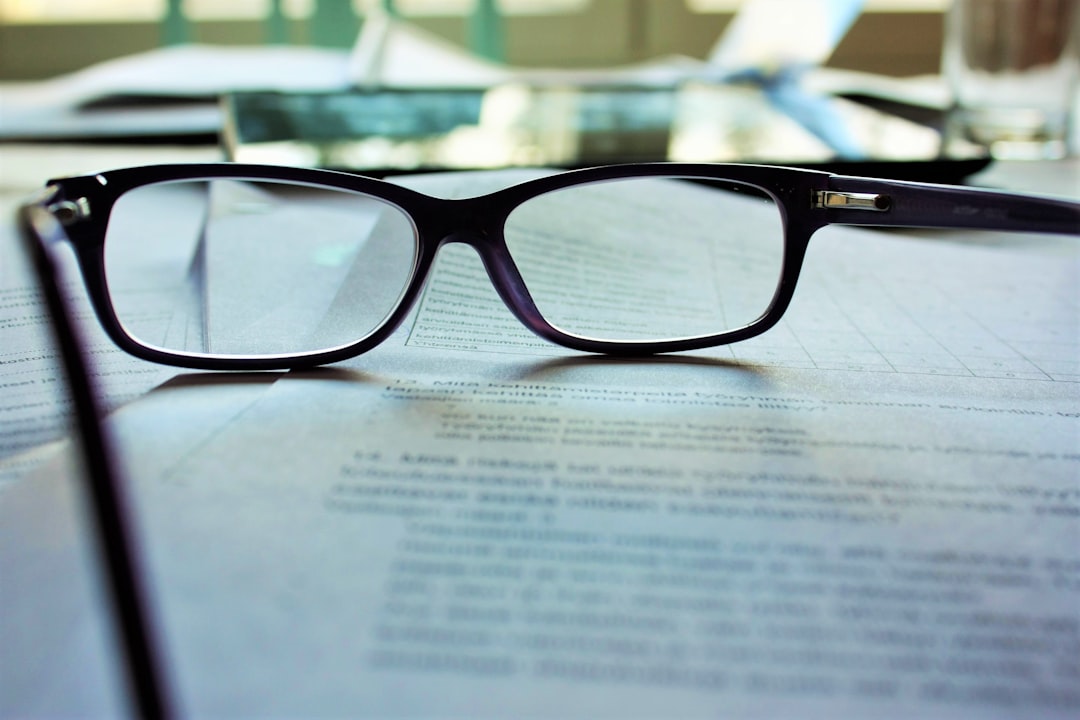office setting with legal documents on the table and a pair of glasses resting on them office setting with legal documents on the table and a pair of glasses resting on them