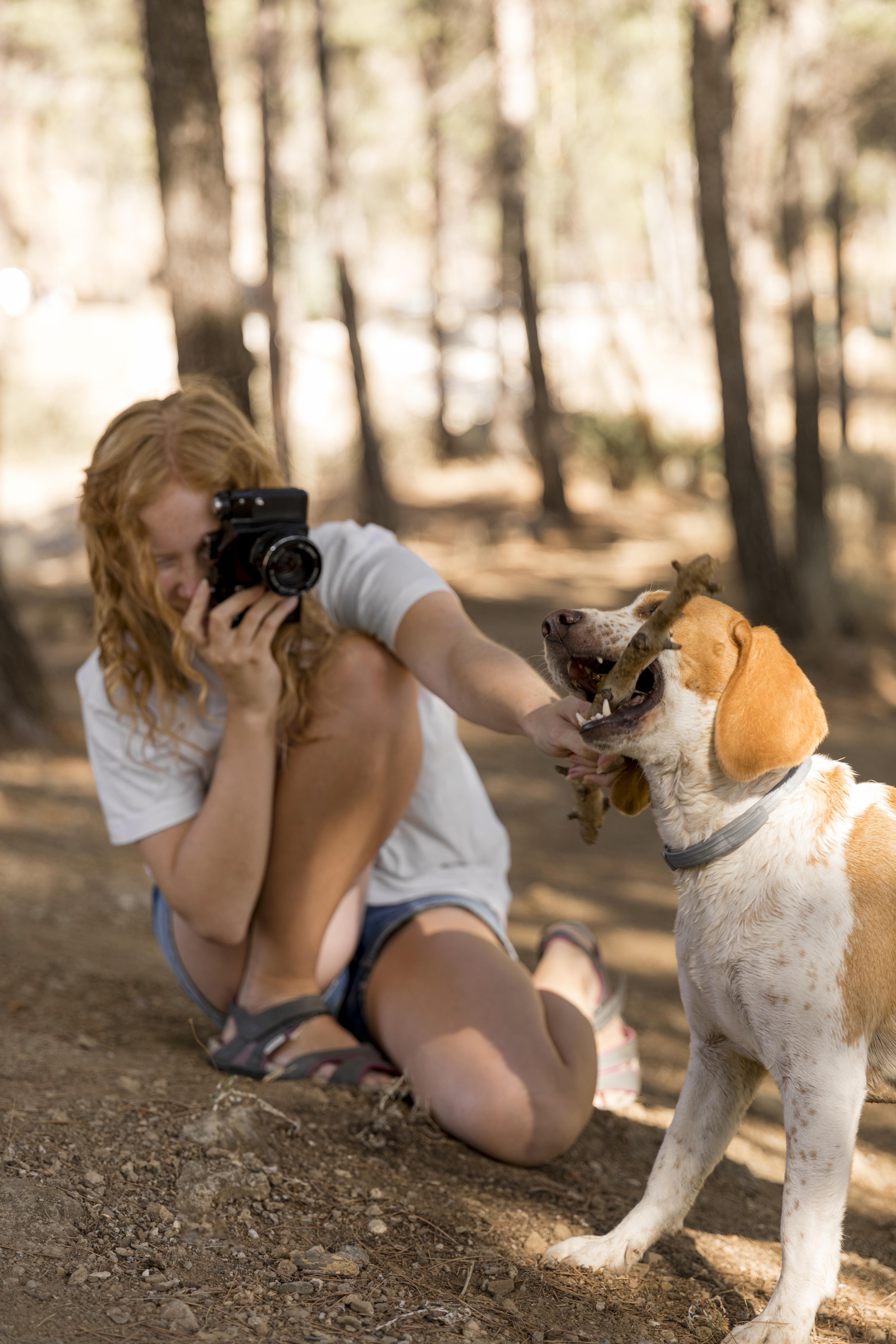 woman taking picture of dog