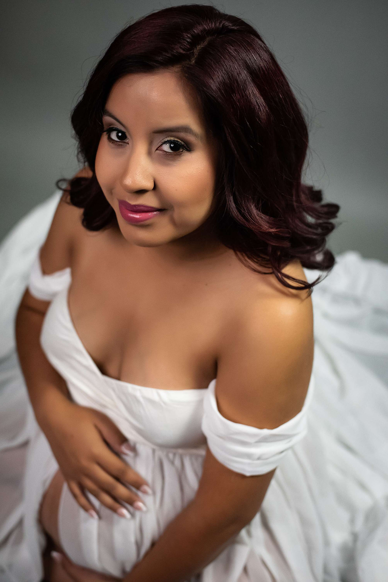 Image photographed by Leslee Shaw Photography in Sweetwater, TX. Dark-haired pregnant woman wearing a white gown.