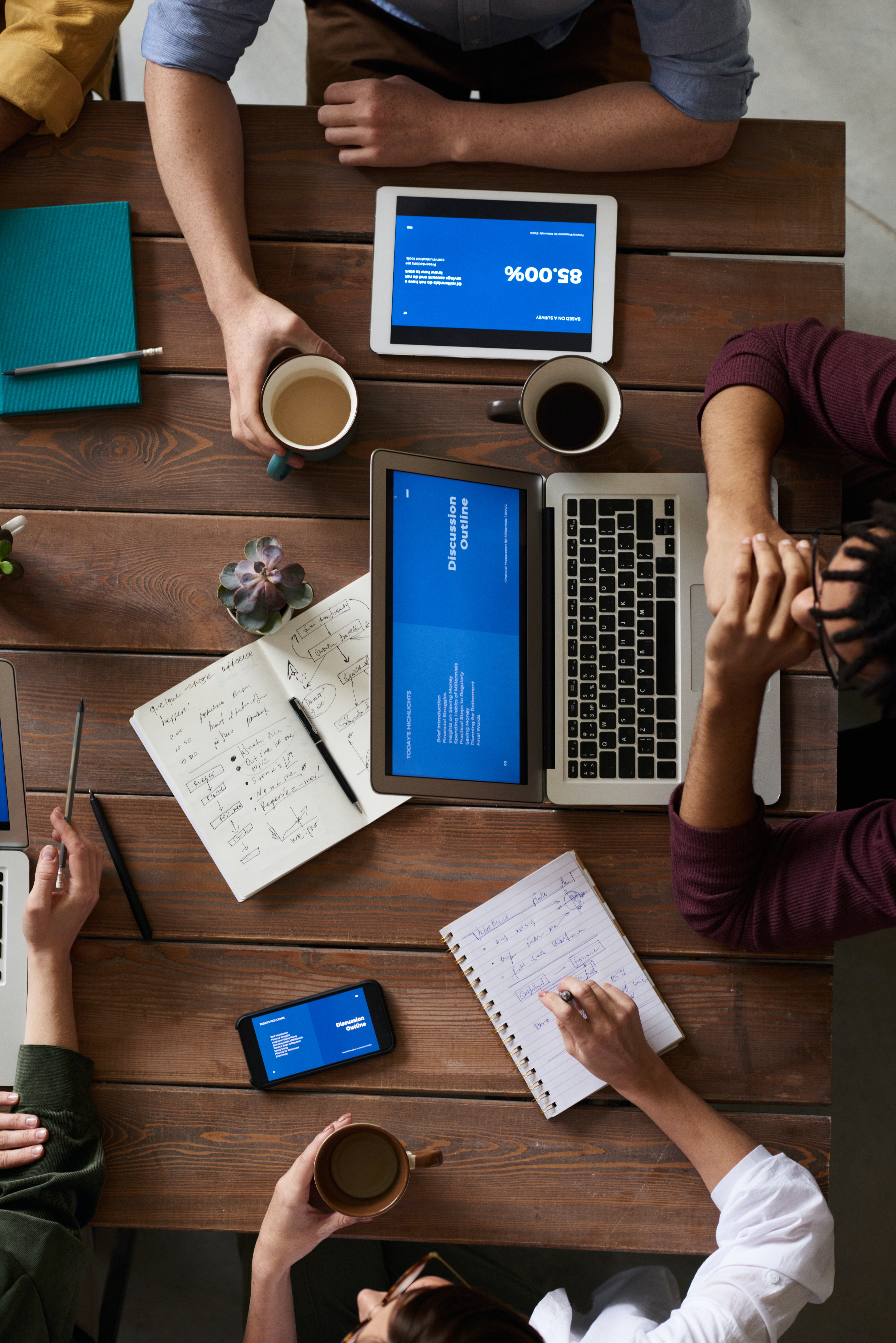 Aerial view of a business meeting addressing financial challenges, featuring a laptop and documents on the table.