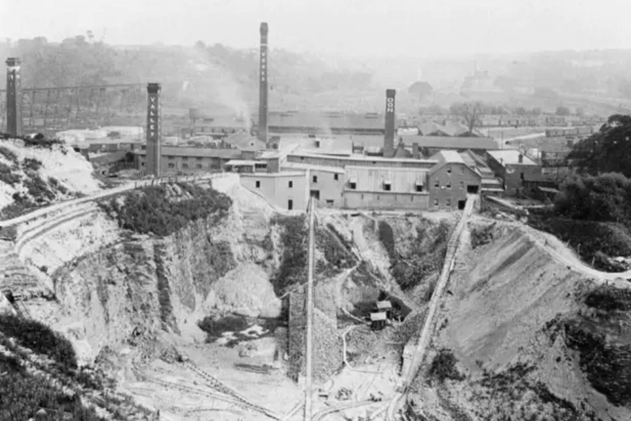 Historic black and white photograph of the original Don Valley Brick Works Toronto showing industrial clay quarry operations, brick kilns with tall smokestacks, and excavated quarry pits before becoming Evergreen Brick Works park