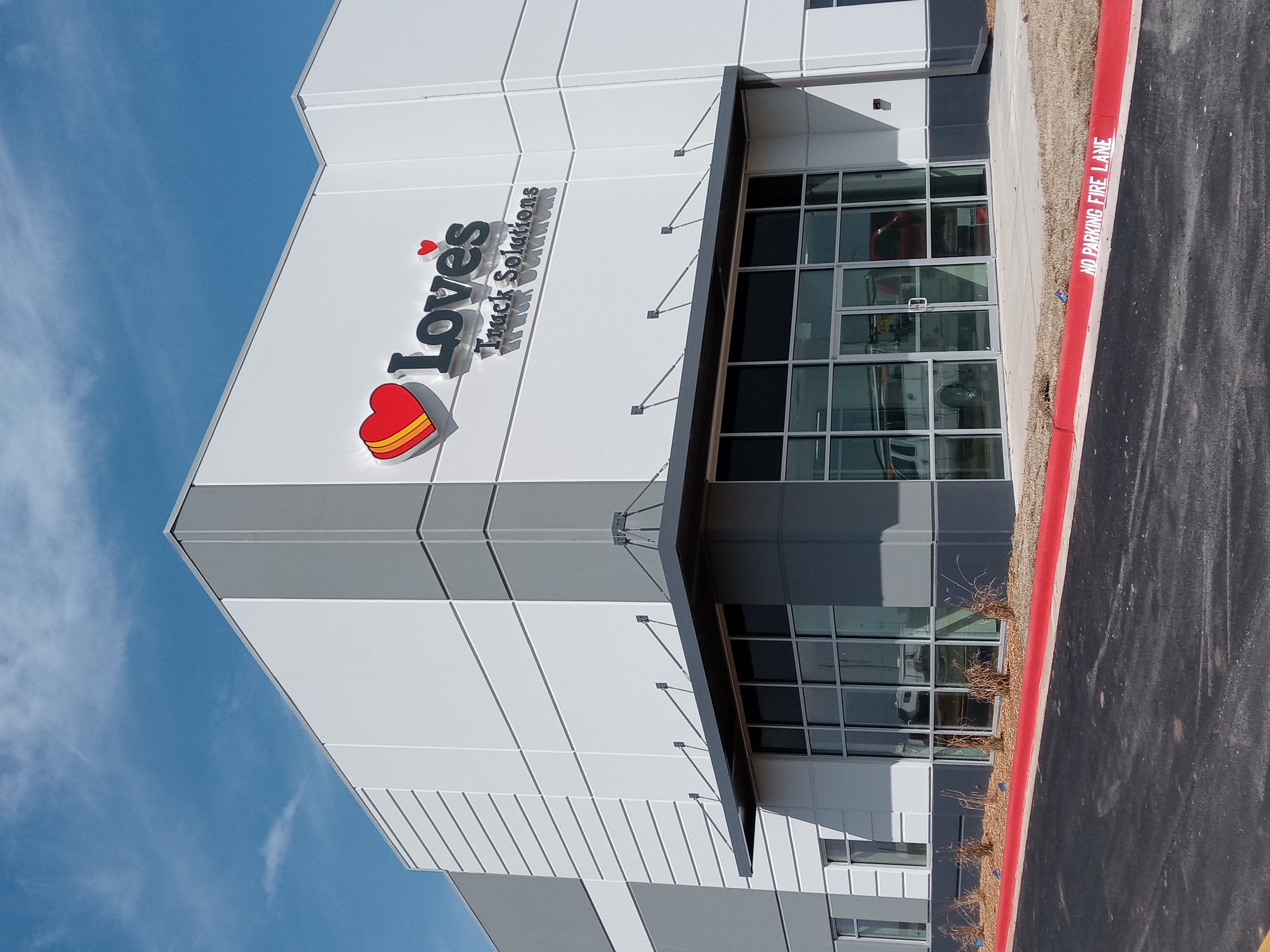 Commercial building with a metal canopy over glass storefront windows at Love’s Truck Solutions.