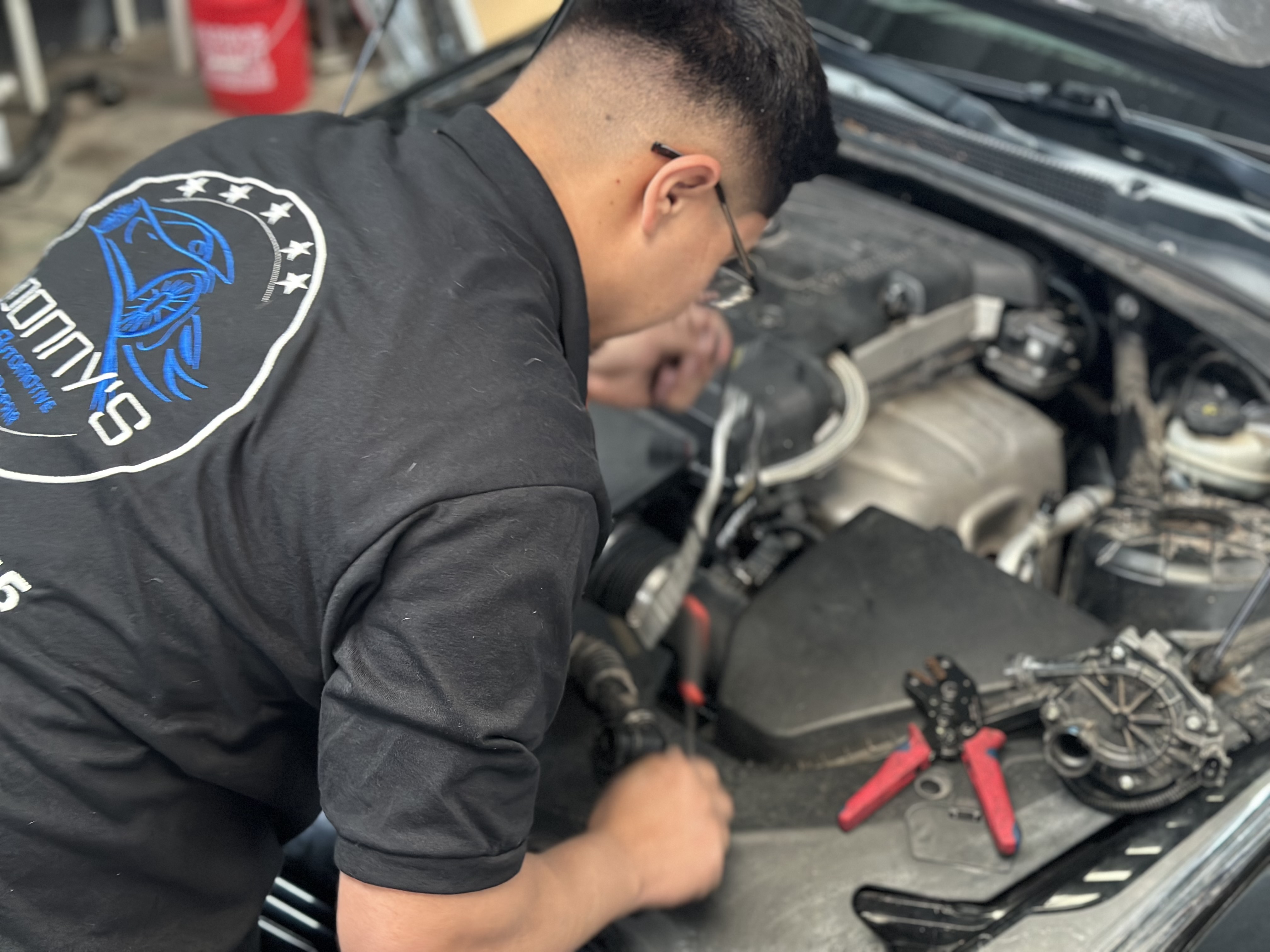 "A mechanic performing an oil change on a car, carefully draining the old engine oil into a pan while preparing to replace the oil filter. The scene highlights the importance of routine maintenance for engine performance and longevity." "A mechanic performing an oil change on a car, carefully draining the old engine oil into a pan while preparing to replace the oil filter. The scene highlights the importance of routine maintenance for engine performance and longevity."