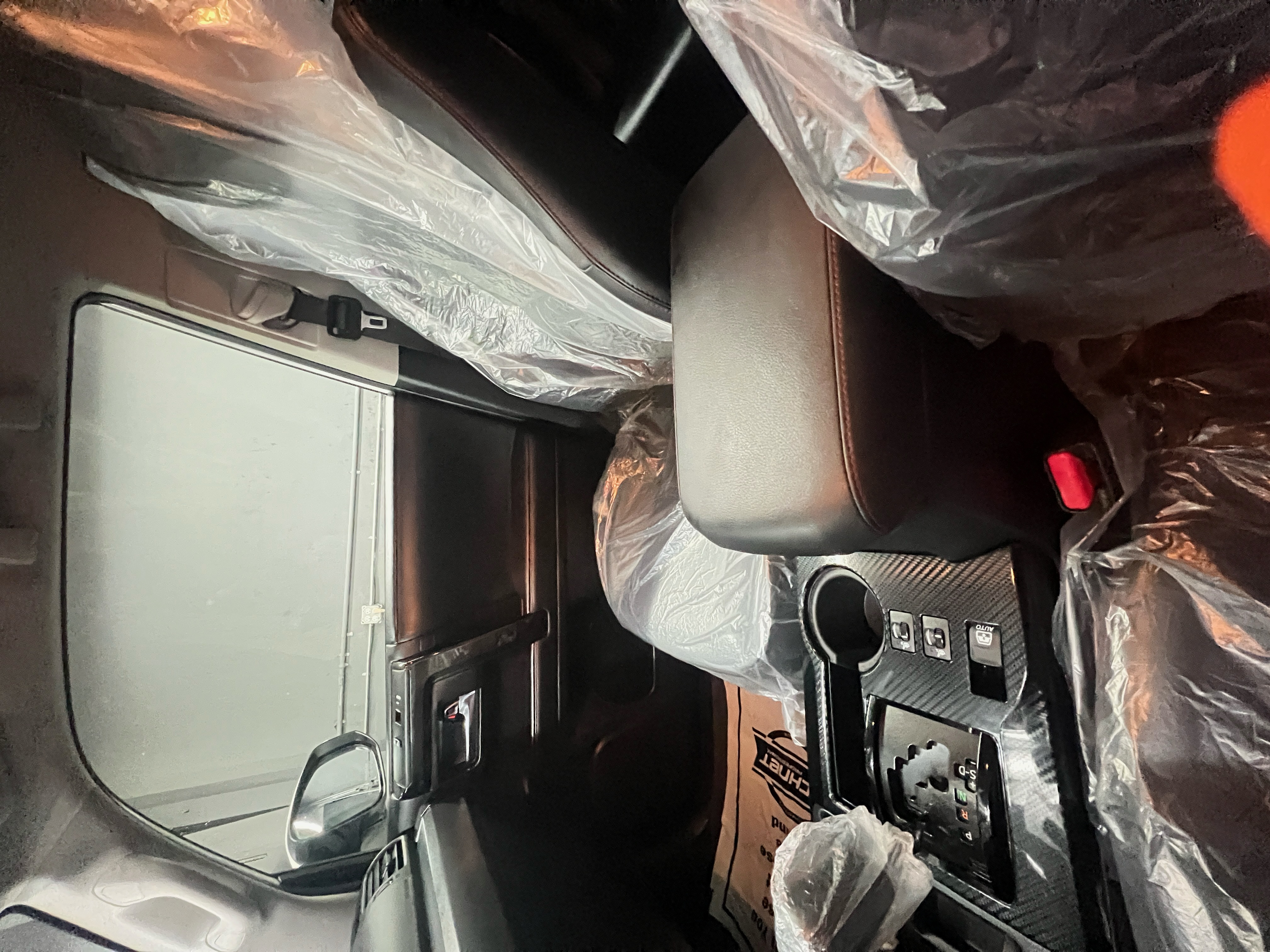 "The interior of a car undergoing professional detailing at RND Detailing and Glass Repair. The seats, steering wheel, and floor are covered with protective plastic coverings, "The interior of a car undergoing professional detailing at RND Detailing and Glass Repair. The seats, steering wheel, and floor are covered with protective plastic coverings,