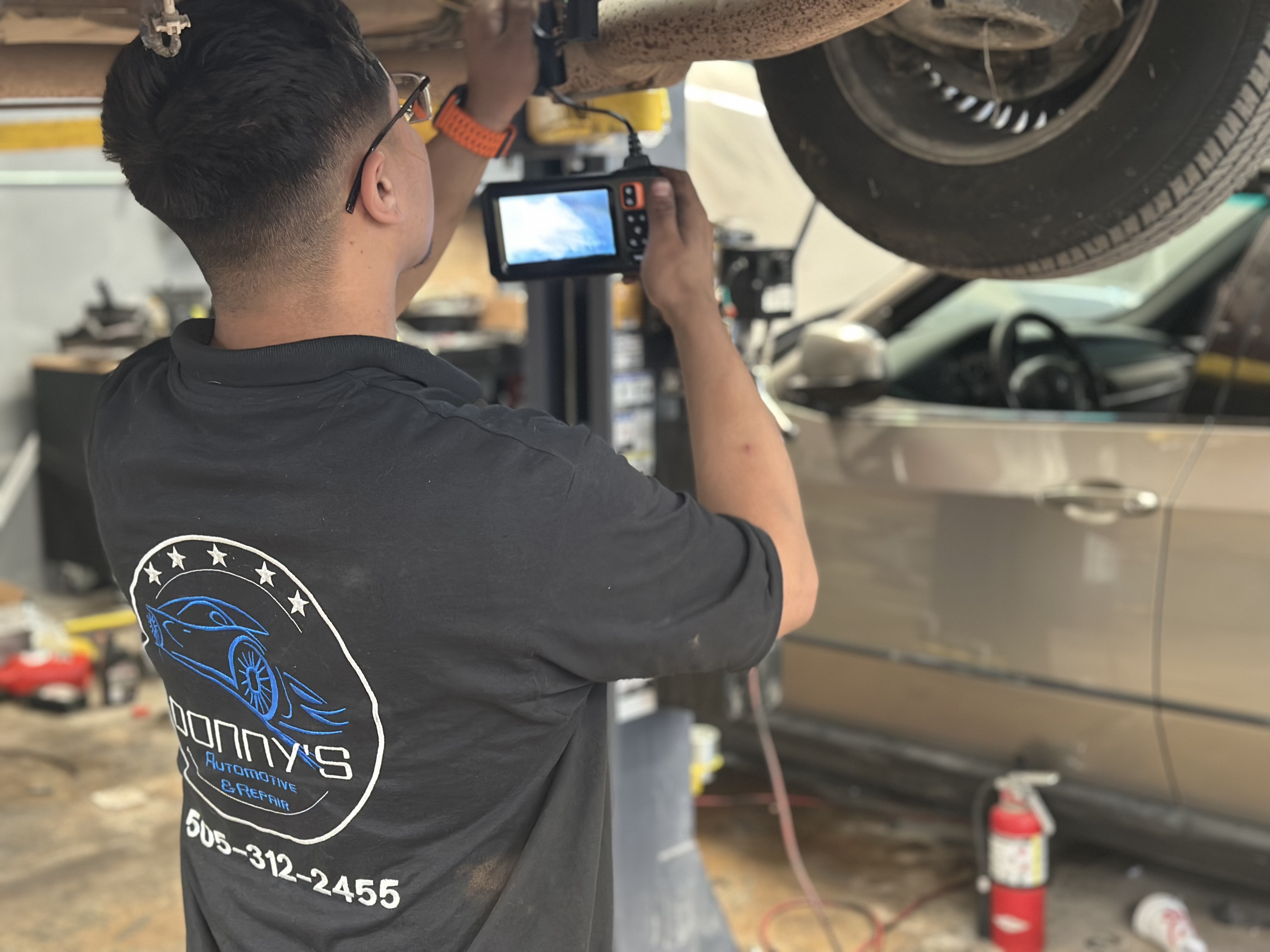 "Technician at Donny's Automotive LLC expertly working on a car engine in the repair shop, showcasing attention to detail and quality service." Create ALT text for driving car "Technician at Donny's Automotive LLC expertly working on a car engine in the repair shop, showcasing attention to detail and quality service." Create ALT text for driving car