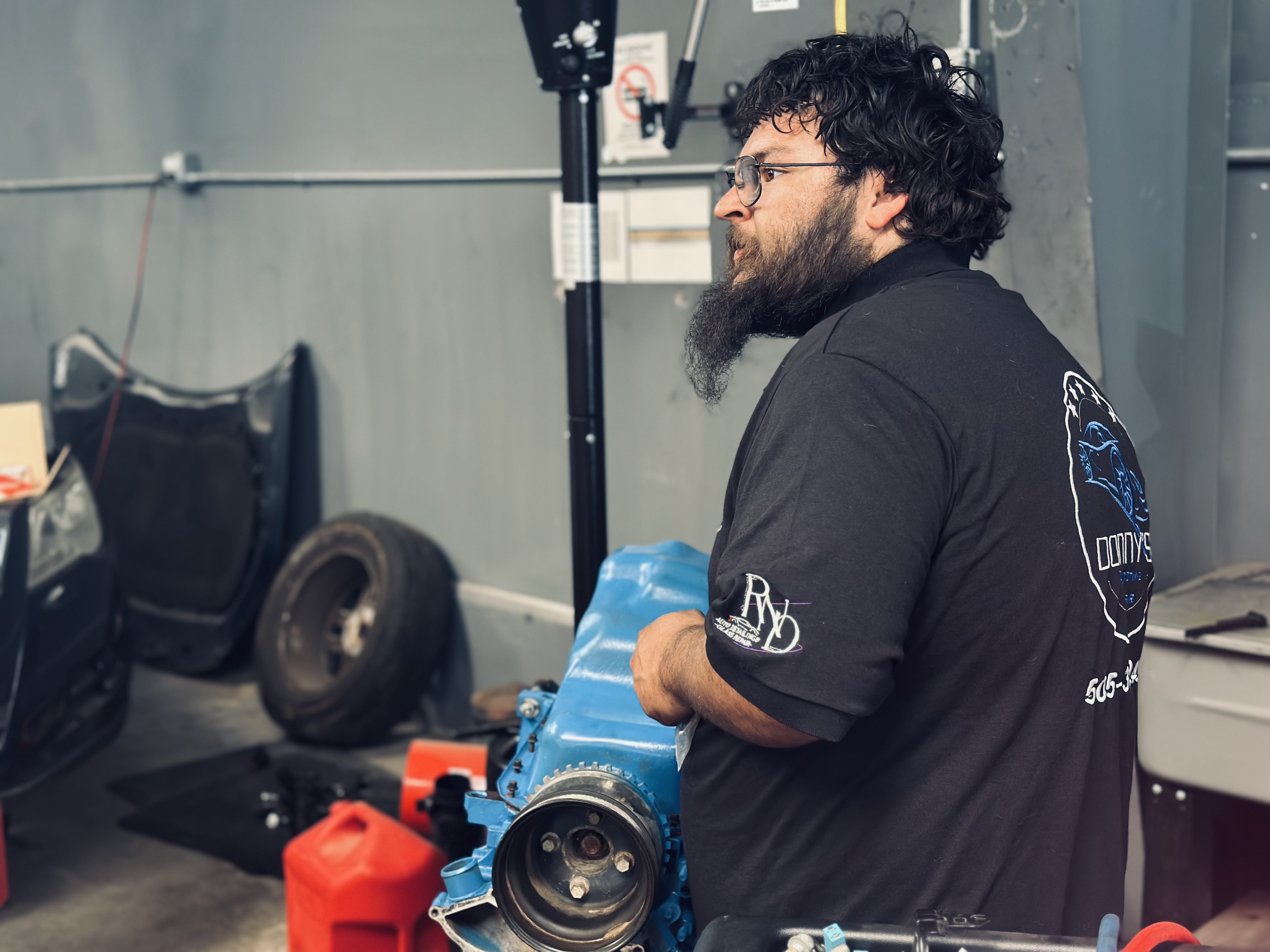 "An employee at Donny's Automotive LLC carefully working on a motor in the repair shop, showcasing attention to detail and expertise in automotive repairs." "An employee at Donny's Automotive LLC carefully working on a motor in the repair shop, showcasing attention to detail and expertise in automotive repairs."