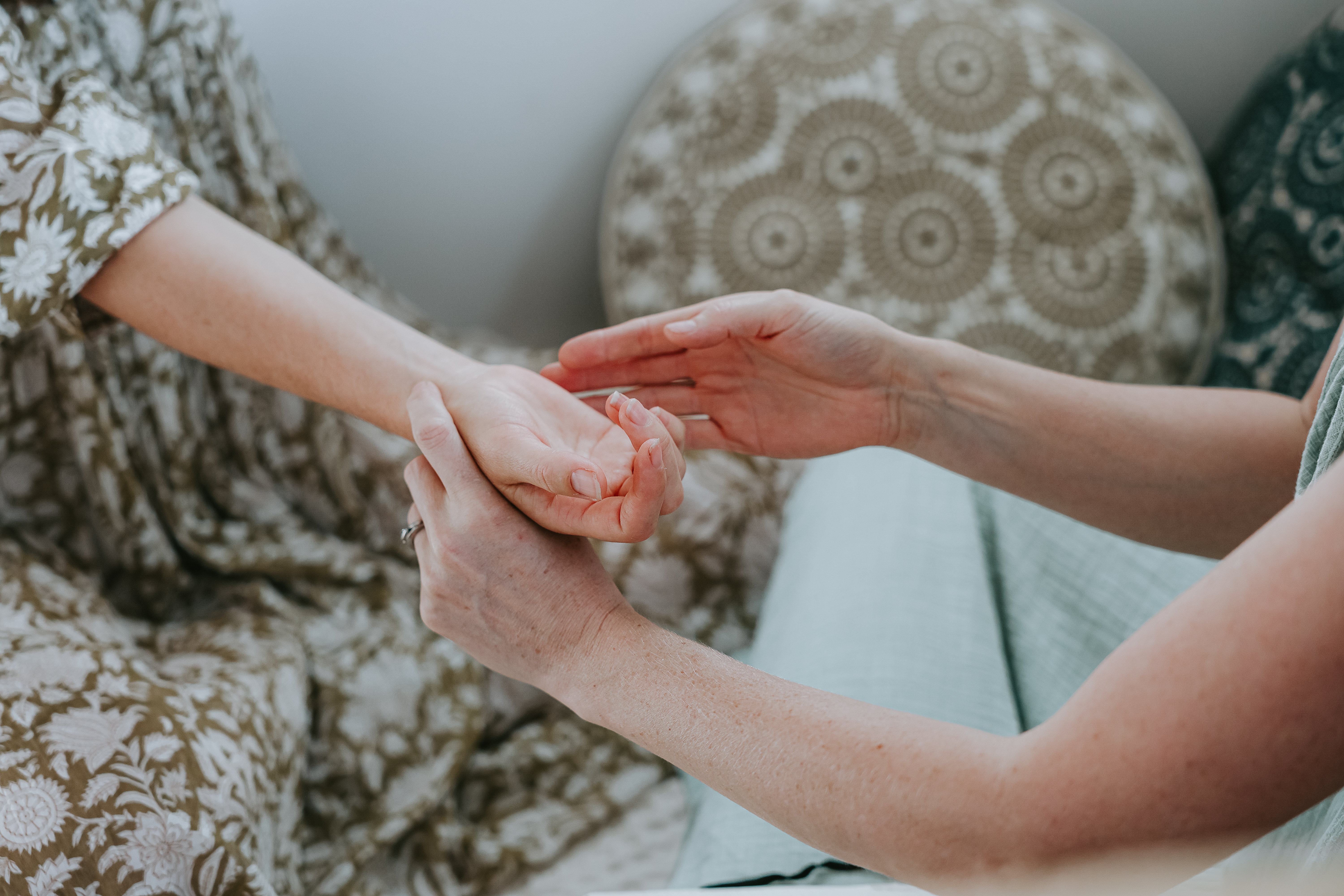 Zoe's hands holding a clients hands doing emotional healing work