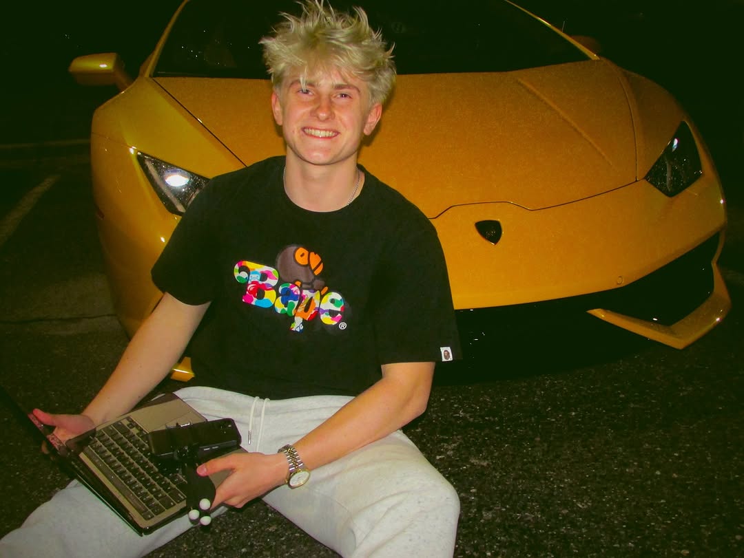 Ryan Okragly sitting in front of a yellow Lamborghini