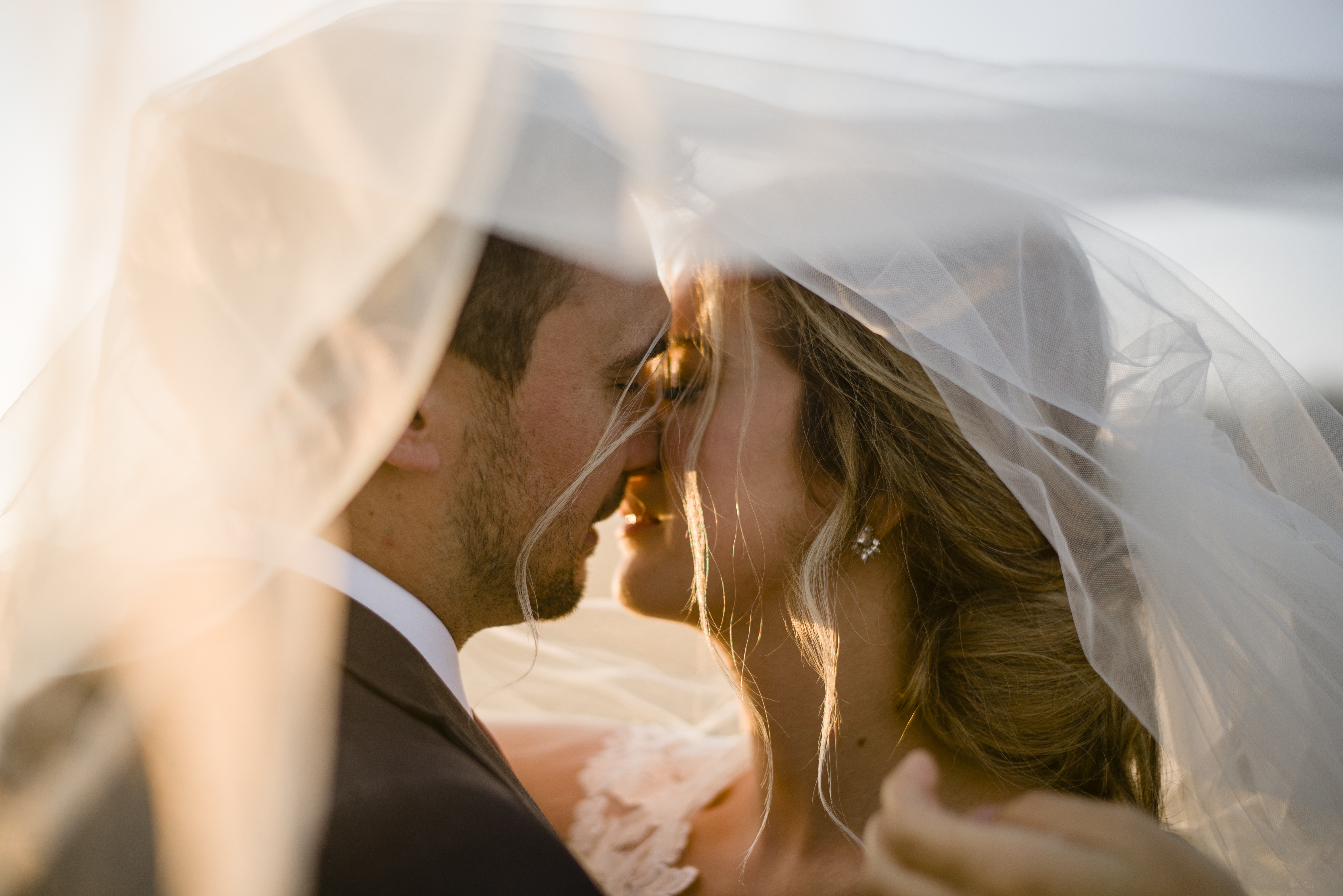 couple kissing under the veil at sunset
