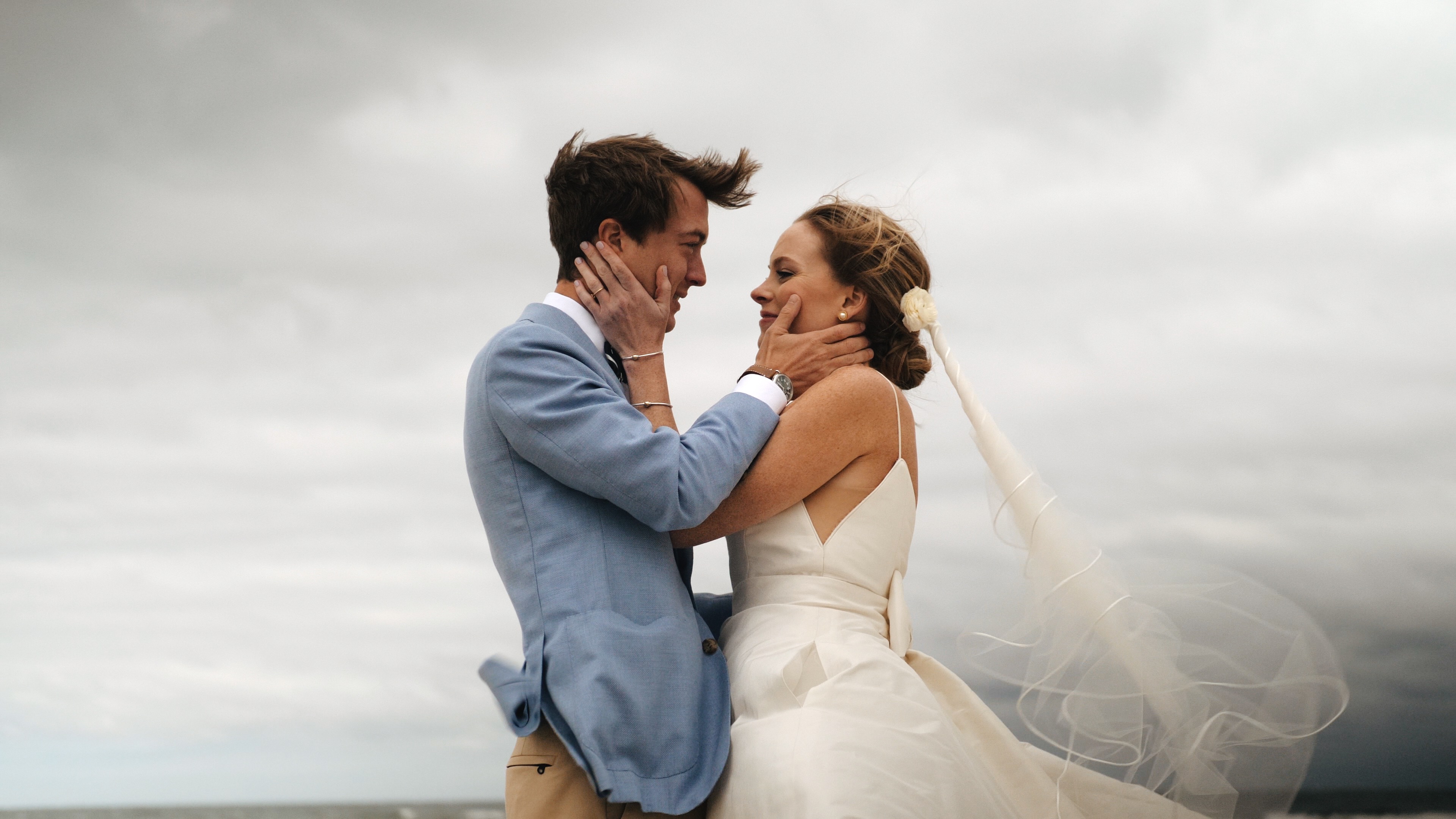 couple standing during a hurricane, wind blowing