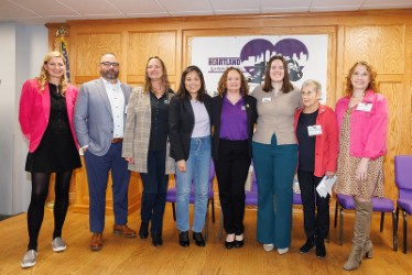A group of women standing in a line and smiling for the camera.