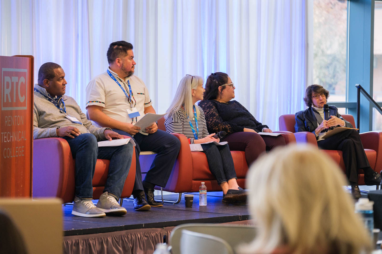 A group of people sitting on stage.