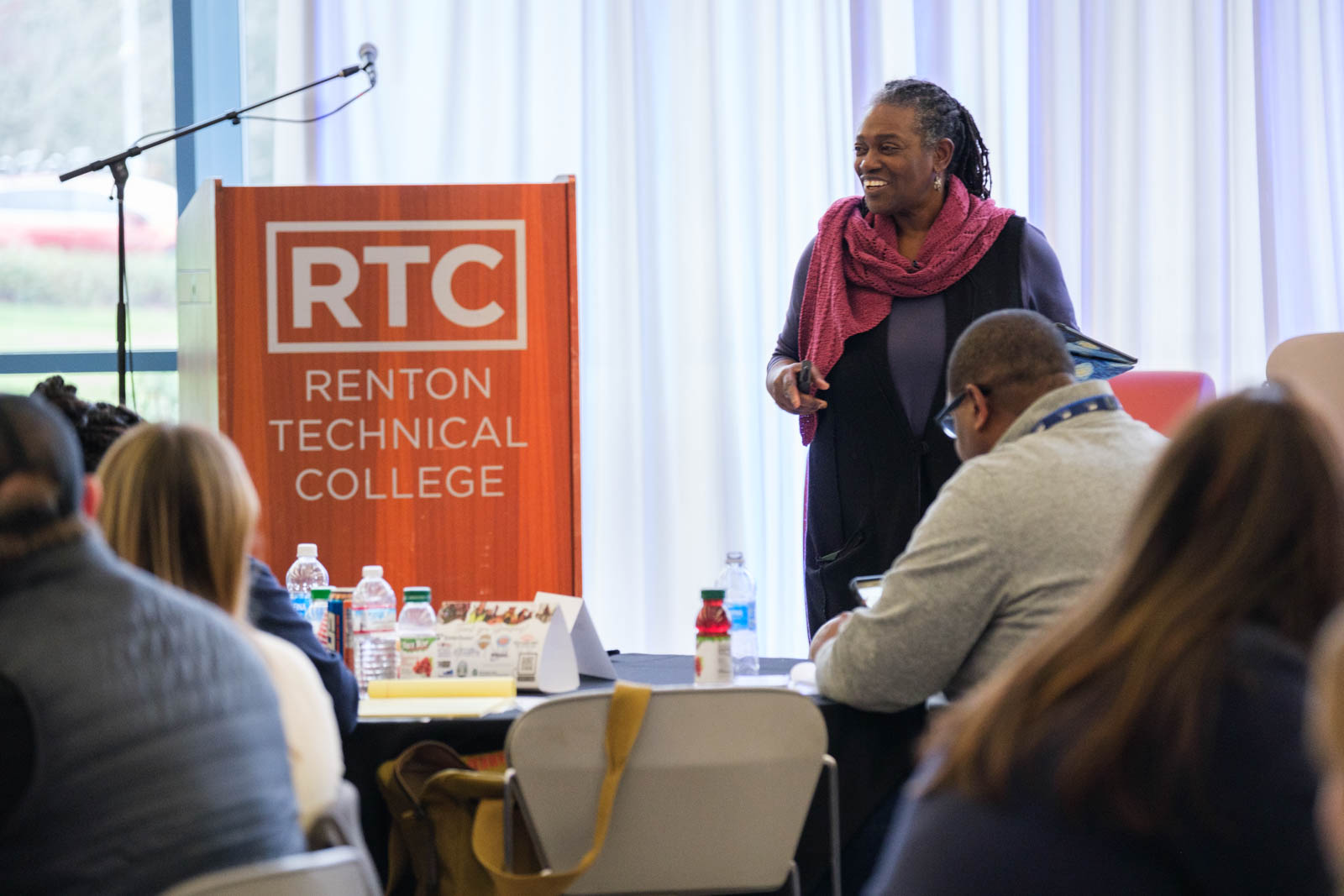 A woman in a red scarf on stage.