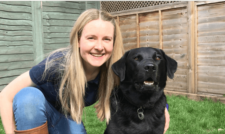 Woman and Dog sitting together looking content.
