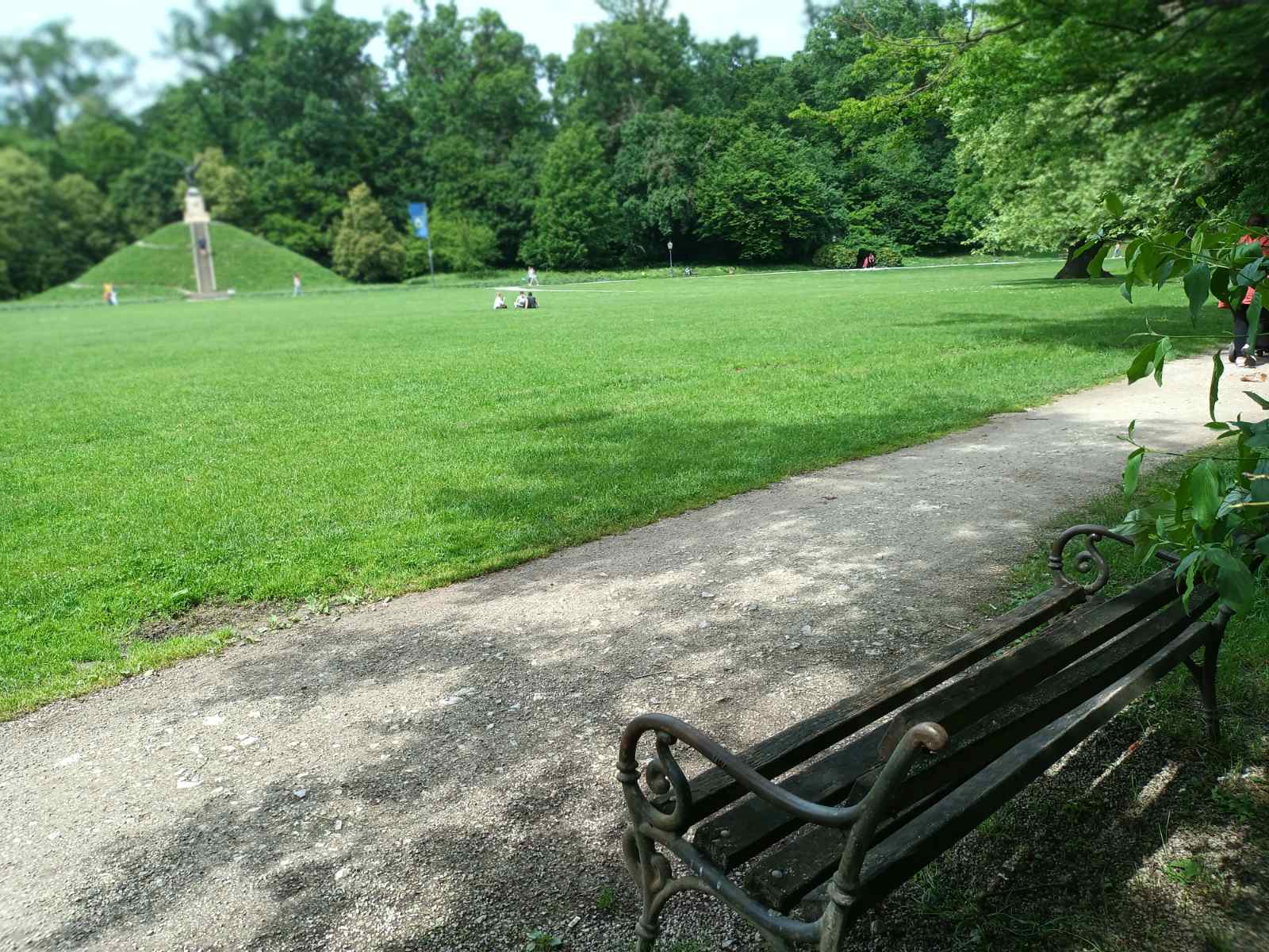 Bench in Maksimir Park, Zagreb, overlooking the historic Mogila monument with the falcon statue, surrounded by lush greenery. Bench in Maksimir Park, Zagreb, overlooking the historic Mogila monument with the falcon statue, surrounded by lush greenery.