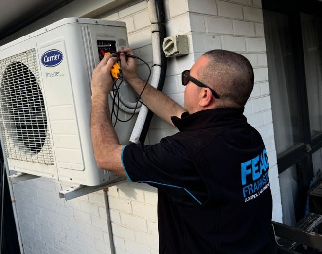 "Professional Frankston electrician installing an energy-efficient air conditioning unit for a comfortable home, featuring expert service and support with Victorian Government rebate incentives."
