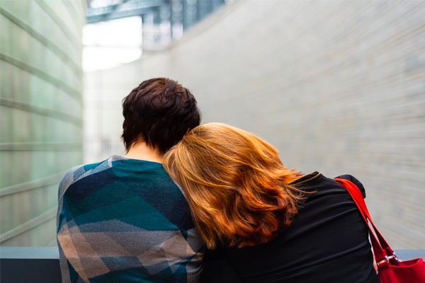 A couple sitting close together, with one partner resting their head on the other's shoulder, symbolizing comfort and support in a loving relationship. A couple sitting close together, with one partner resting their head on the other's shoulder, symbolizing comfort and support in a loving relationship.