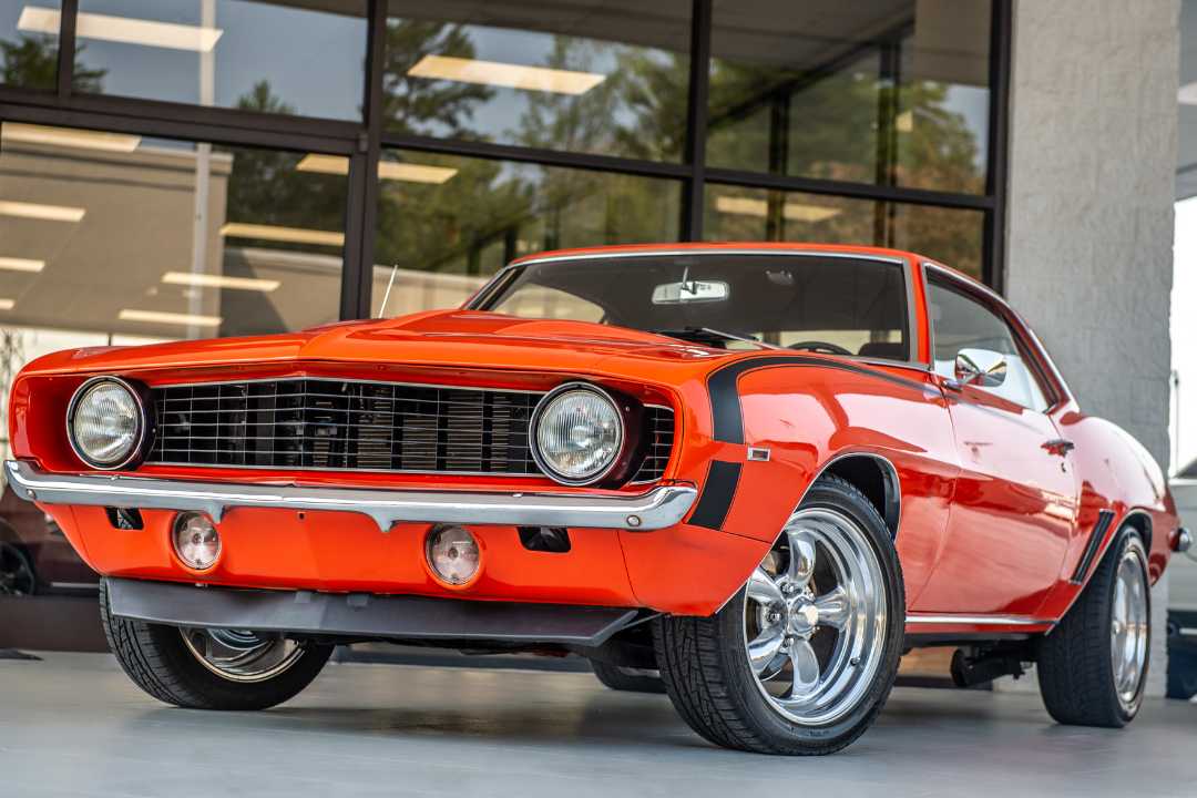 Restored orange classic car standing proudly at dealership entrance, highlighting heritage and legal car registration California. Restored orange classic car standing proudly at dealership entrance, highlighting heritage and legal car registration California.