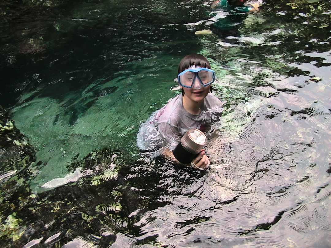 My son is hanging on to the side of the small swimming by his arms, holding a diving flashlight, goggles on, and a big smile. My son is hanging on to the side of the small swimming by his arms, holding a diving flashlight, goggles on, and a big smile.