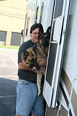 My husband is holding back our two German Shepherds who are trying to "escape" our camper.